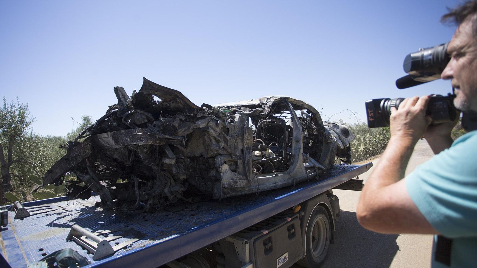 Un cámara de televisión graba el estado en que quedó el coche de Reyes.
