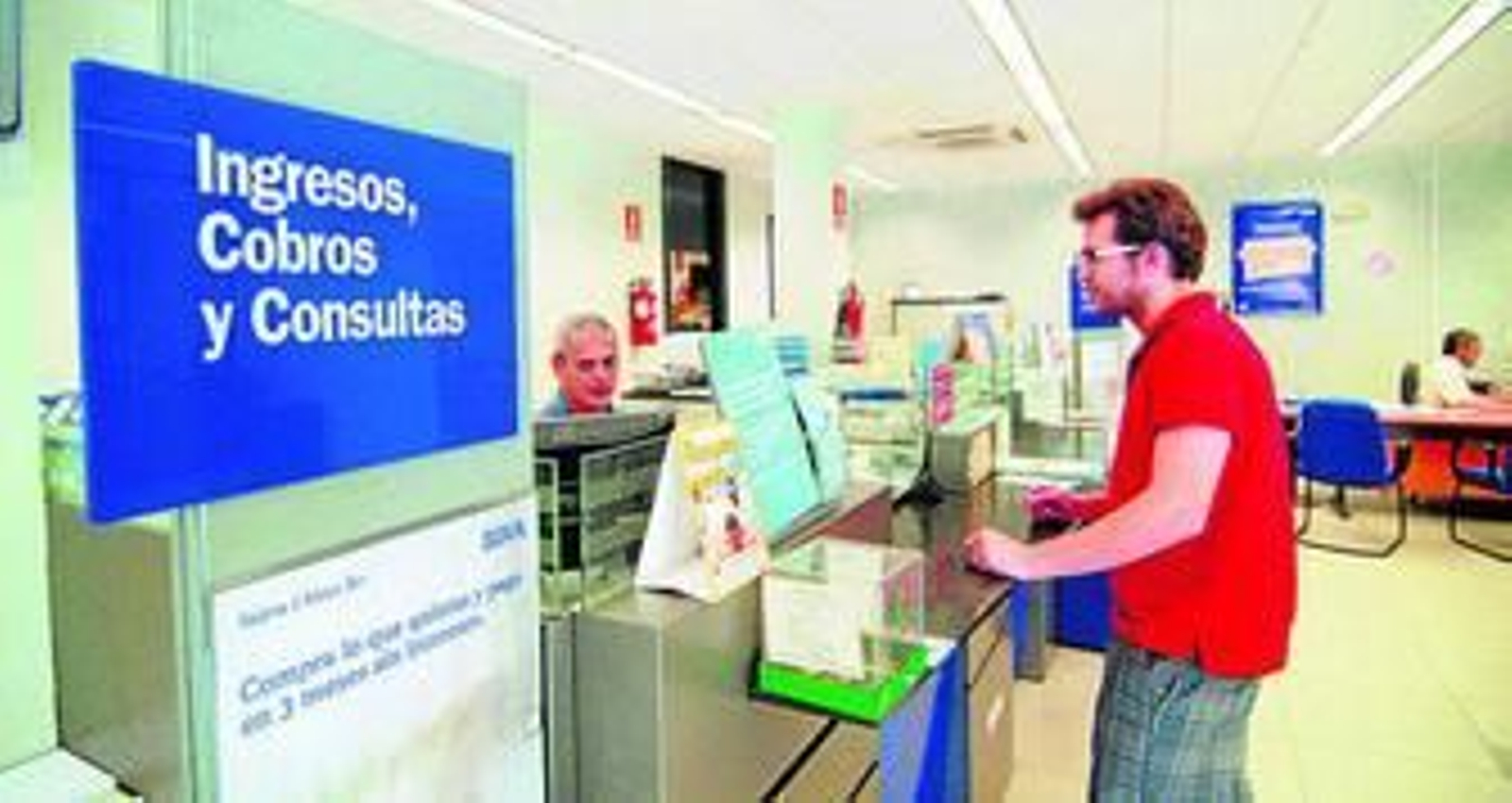 Un cliente hace una gestión en una oficina bancaria.