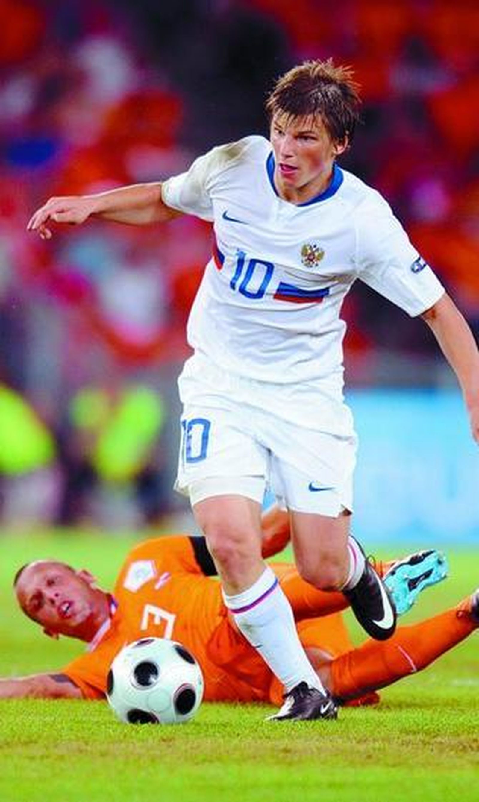 El ruso Arshavin se dispone a dar el centro del segundo gol tras driblar al holandés Heitinga.