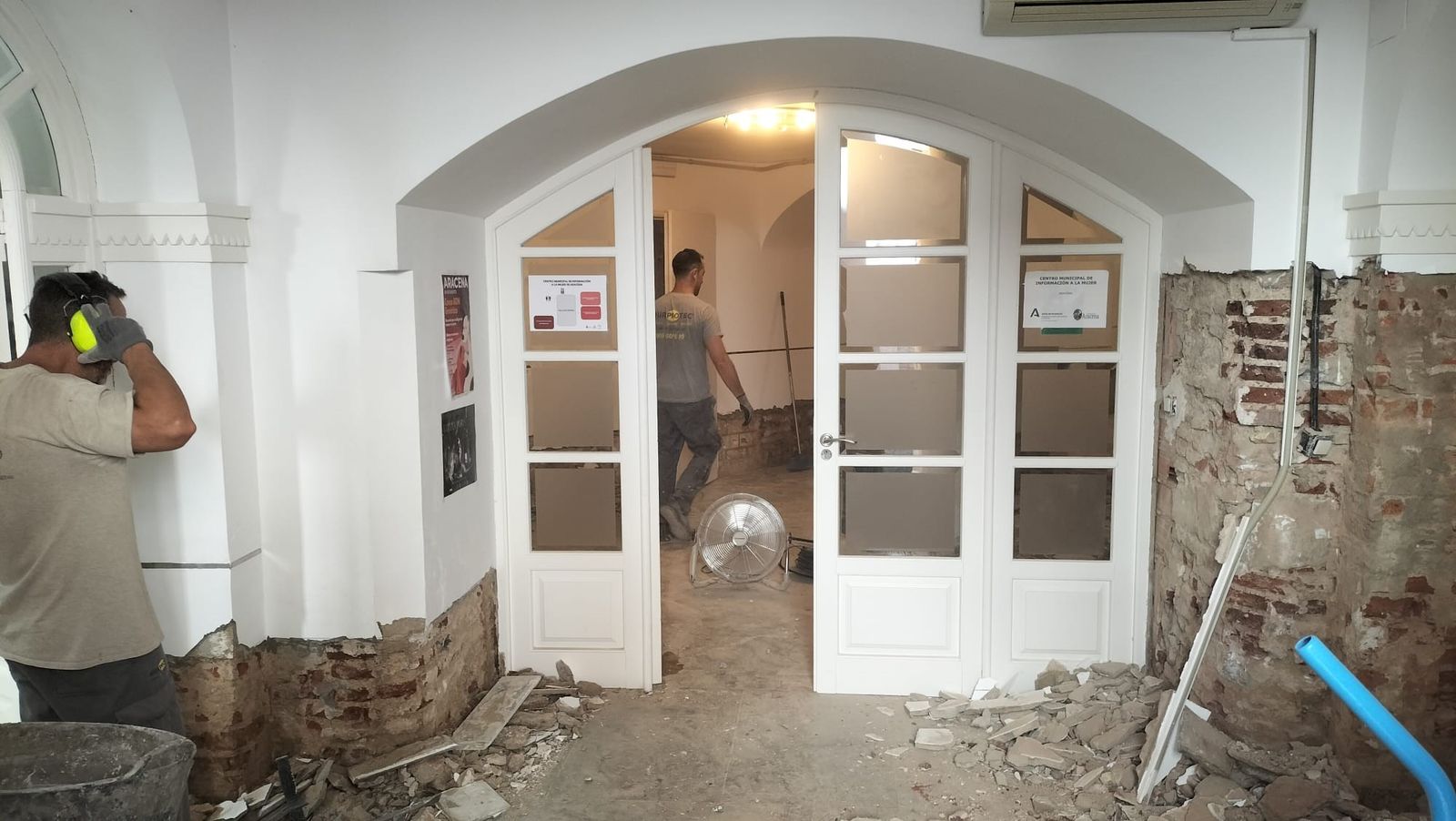 Operarios en las obras por las humedades en la planta baja del edificio.