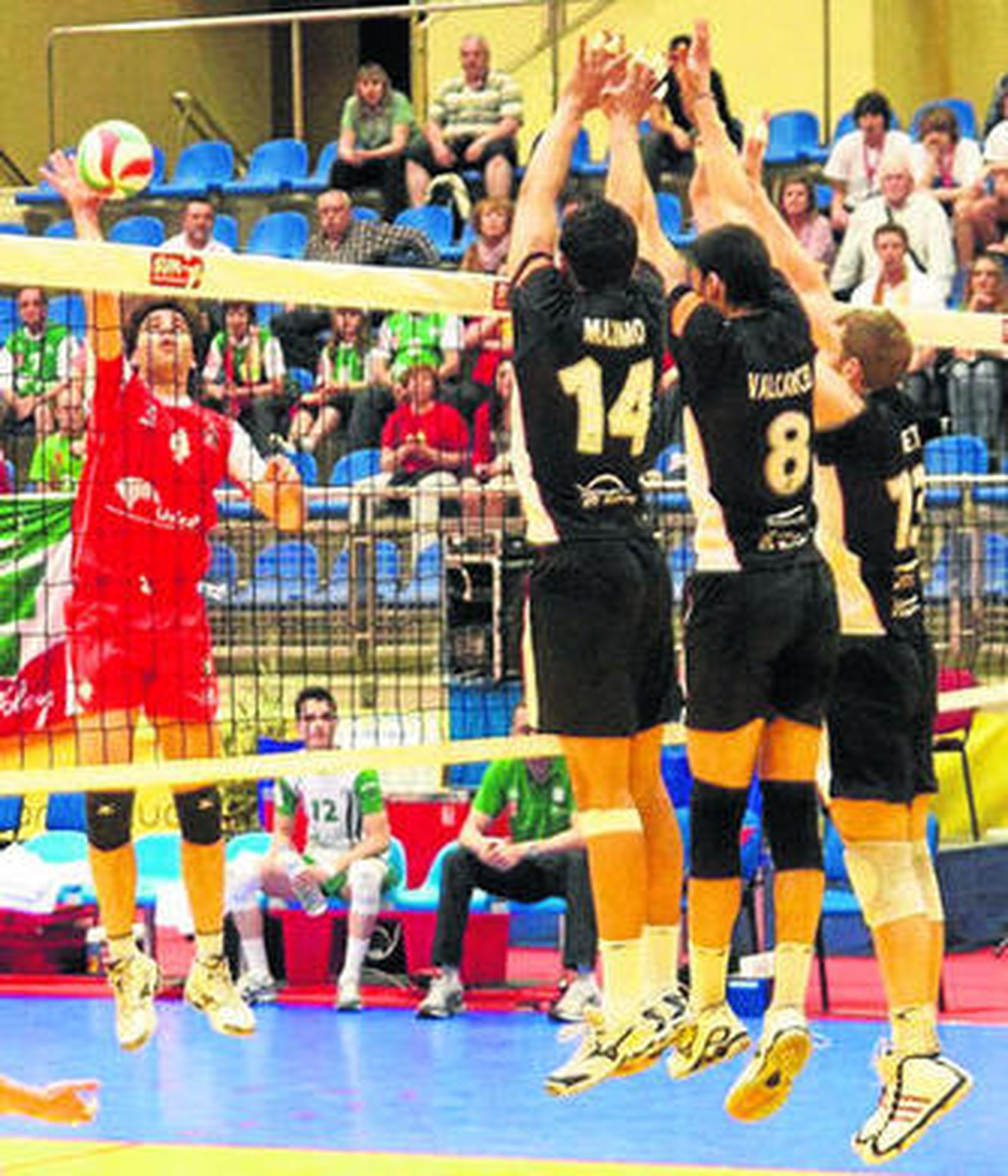 Manolo Sevillano intenta superar el triple bloqueo de los jugadores del Palma Volley.