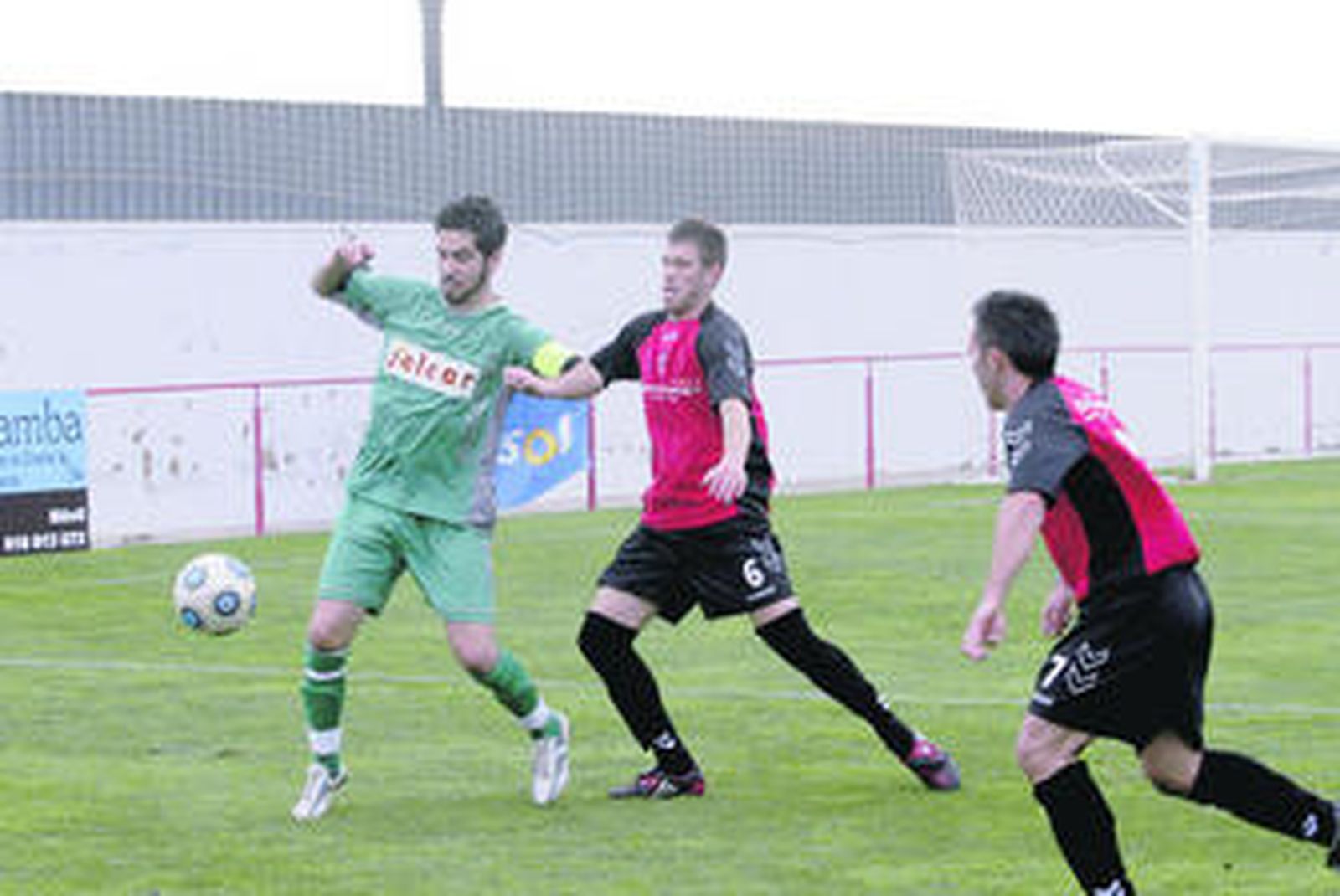 Adri, que fue expulsado, controla el balón ante Carlos.