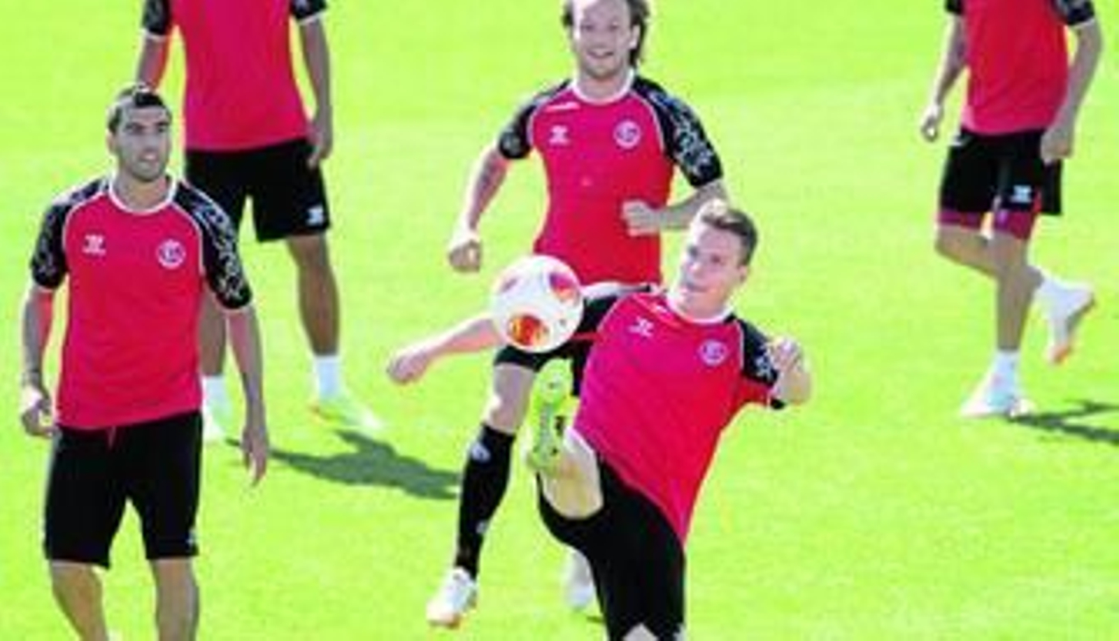 Gameiro estira su pierna derecha para controlar el balón ante Reyes y Rakitic durante el entrenamiento que tuvo el equipo en Sevilla antes de partir hacia Valencia.