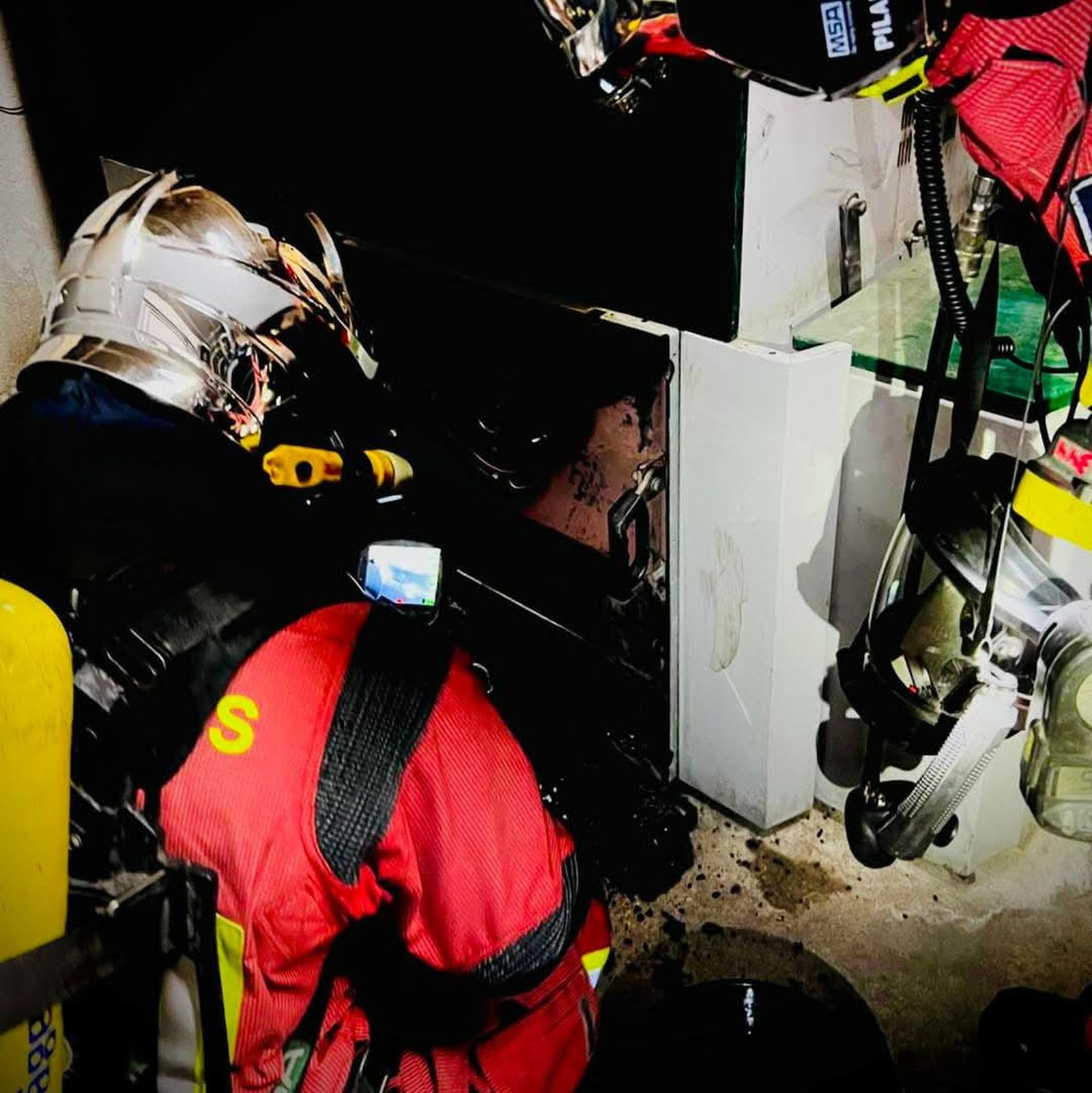 Efectivos del cuerpo de bomberos revisan el origen del humo de la residencia de Cambil.