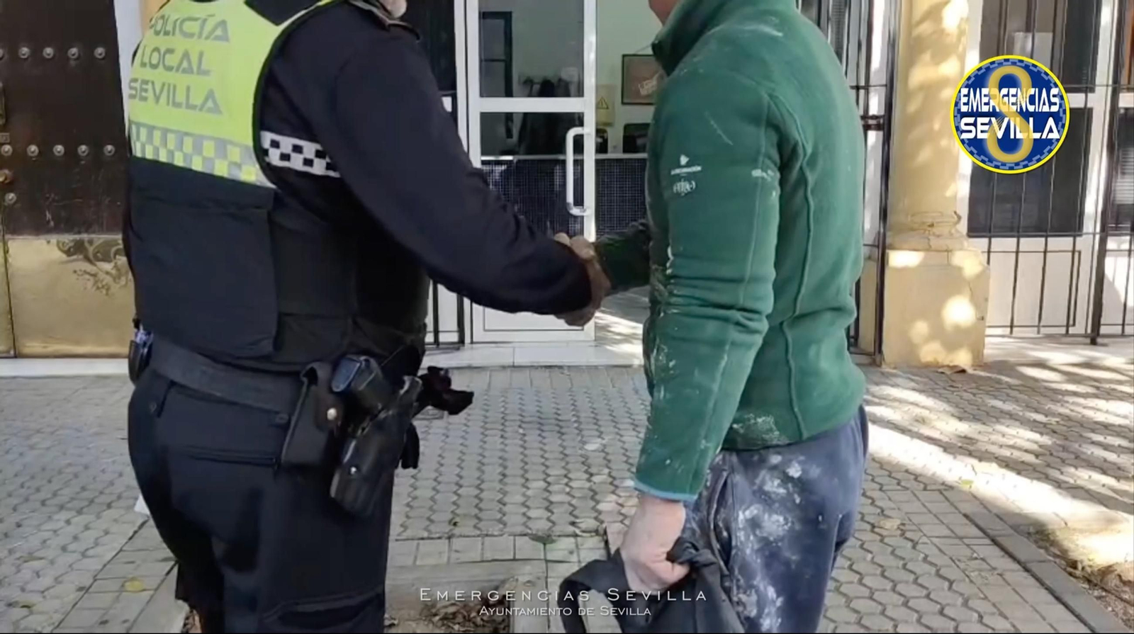 El albañil estrecha la mano de un policía local, tras recuperar el dinero.