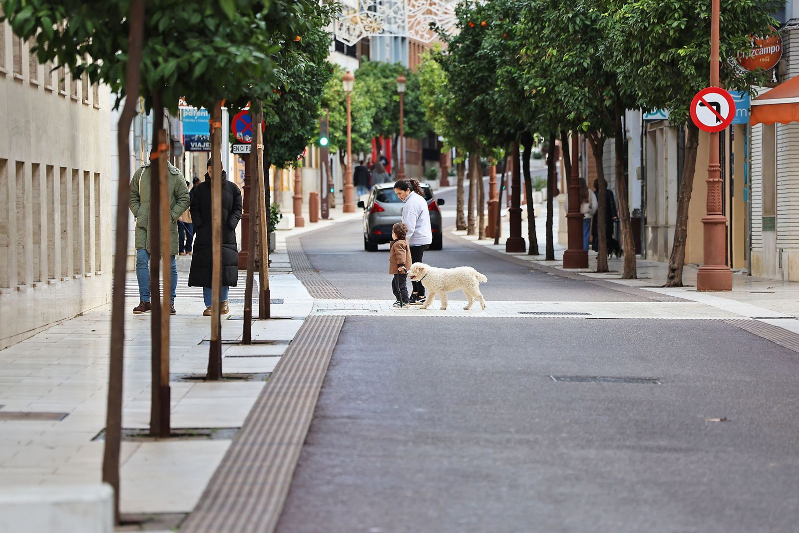 Una pareja camina por una calle de Huelva.