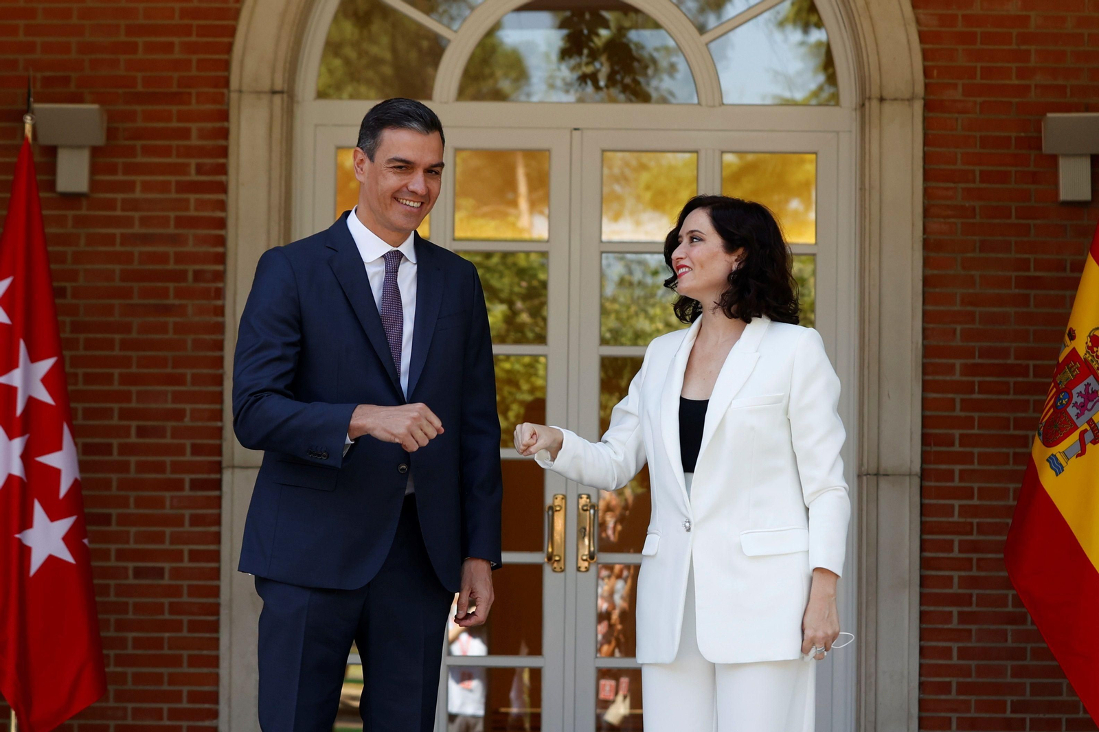 Pedro Sánchez e Isabel Díaz Ayuso se saludan chocando puños en la Moncloa.