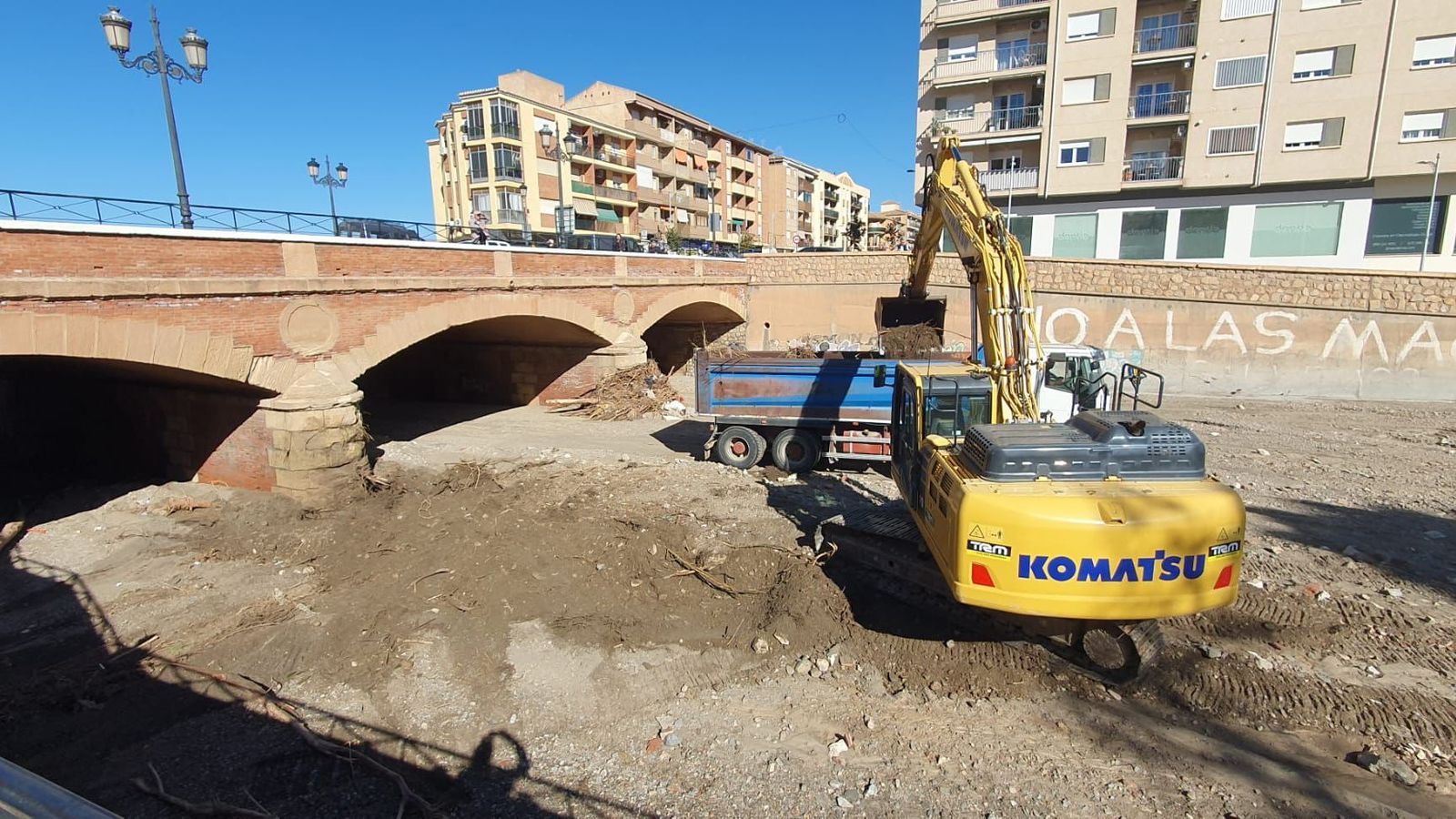 Los trabajos de retirada de los sedimentos acumulados por la riada en el puente de la avenida Buenos Aires de Guadix