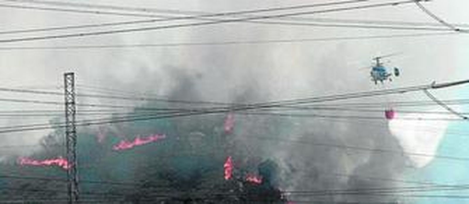 Un helicóptero arroja agua sobre el fuego en Sierra Carbonera.