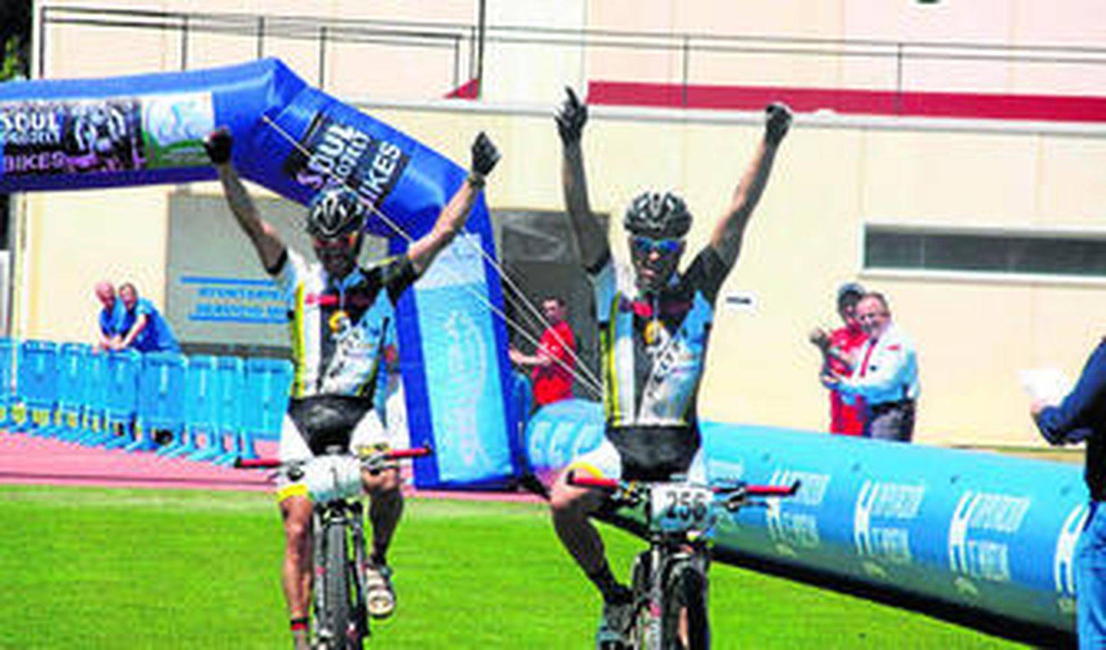 José Carlos Macías y su hermano Javier levantan los brazos tras cruzar la línea de meta en Punta Umbría.