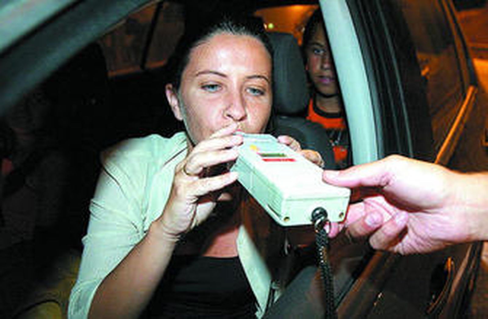 Una conductora realizando la prueba con el alcoholímetro.