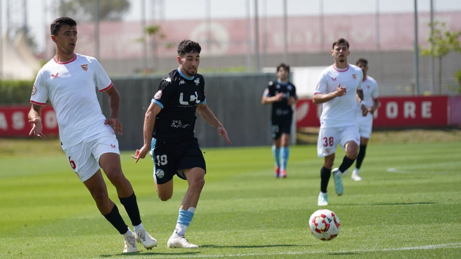 Hugo Fuentes, jugador del Ciudad de Lucena, trata de robar el balón a un defensor del Sevilla C.