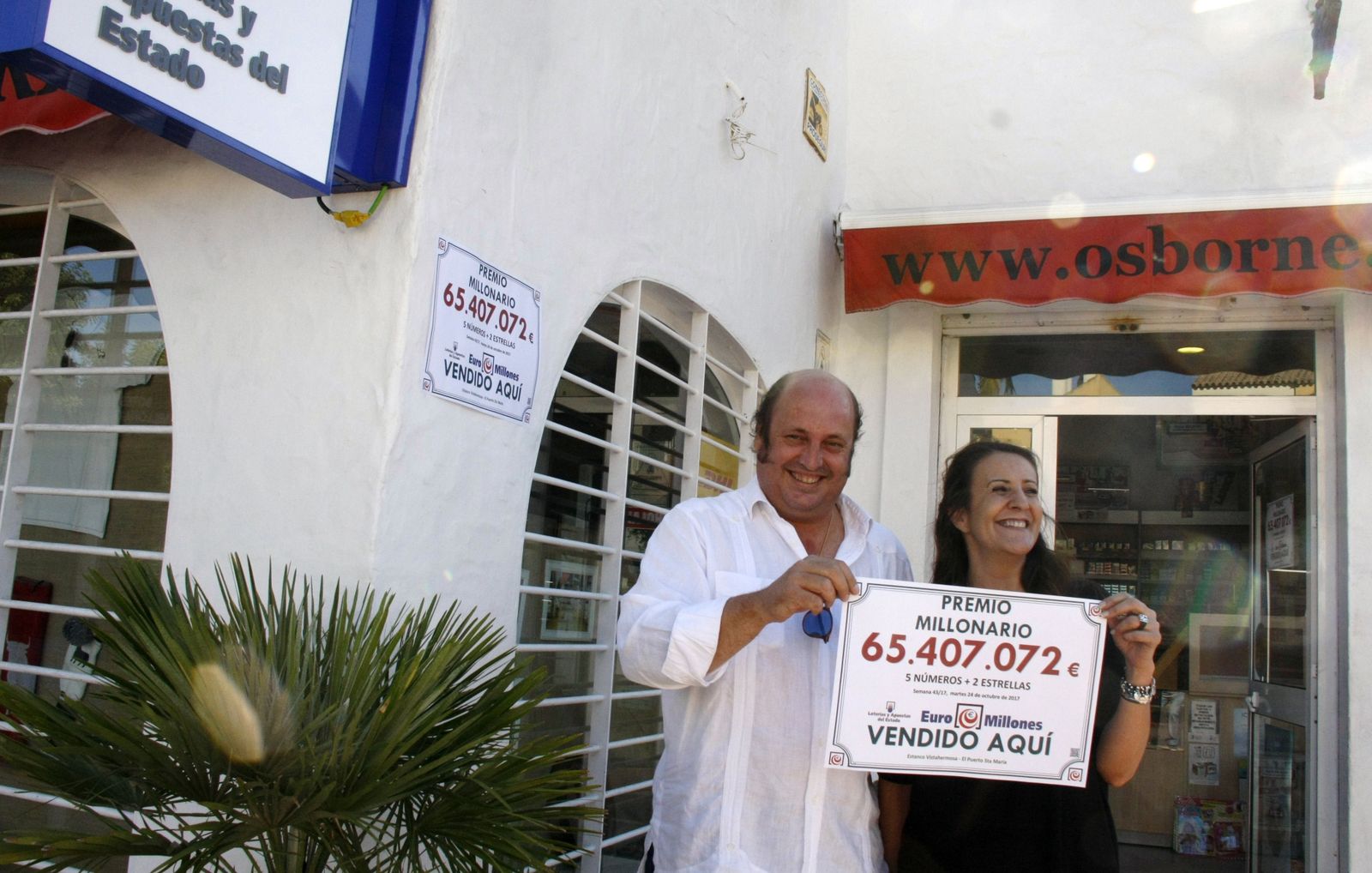 El dueño del estanco, Diego Terry, junto a una empleada del establecimiento mostrando la combinación ganadora.