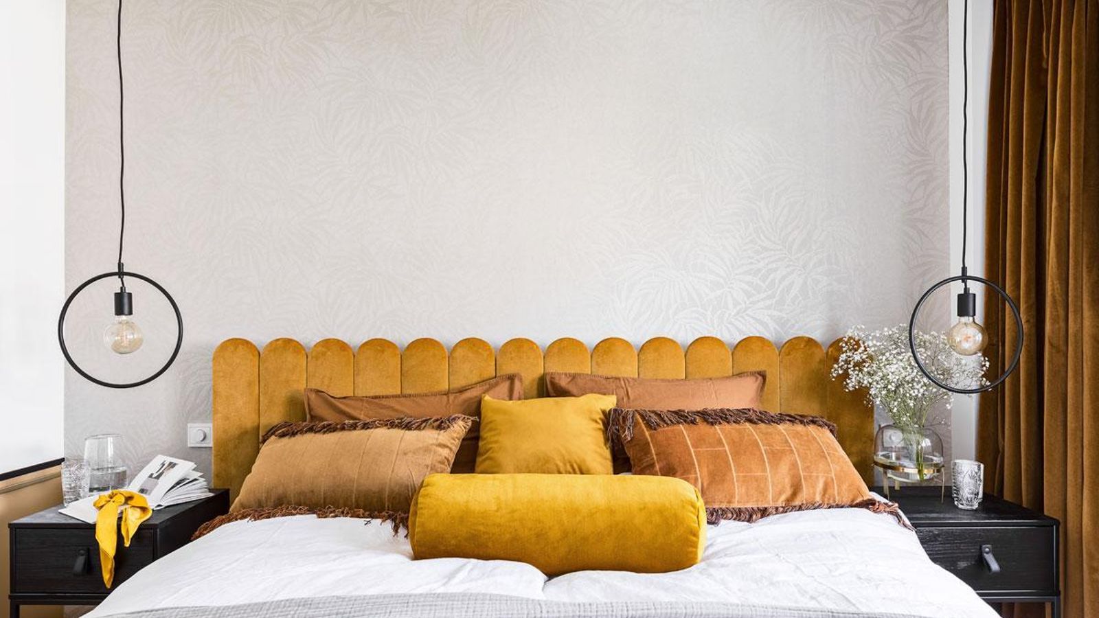 Dormitorio con dos lámparas colgantes sobre las mesitas de noche.