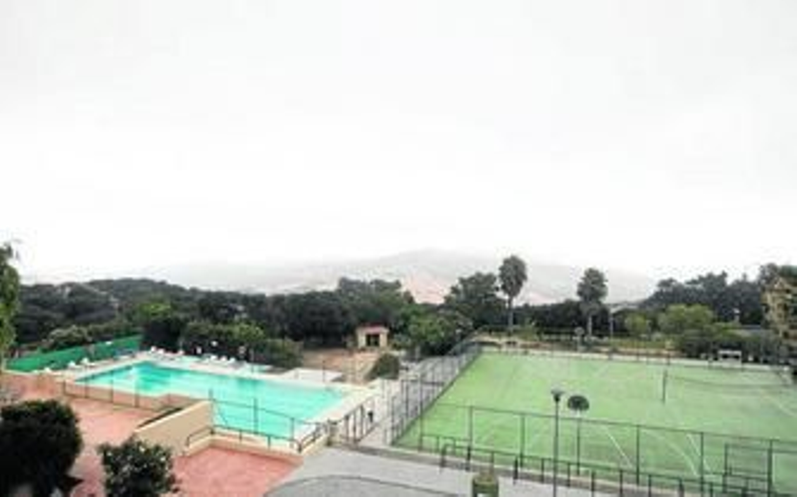 La piscina y las pistas deportivas del albergue, con el Parque Natural del Estrecho, al fondo.