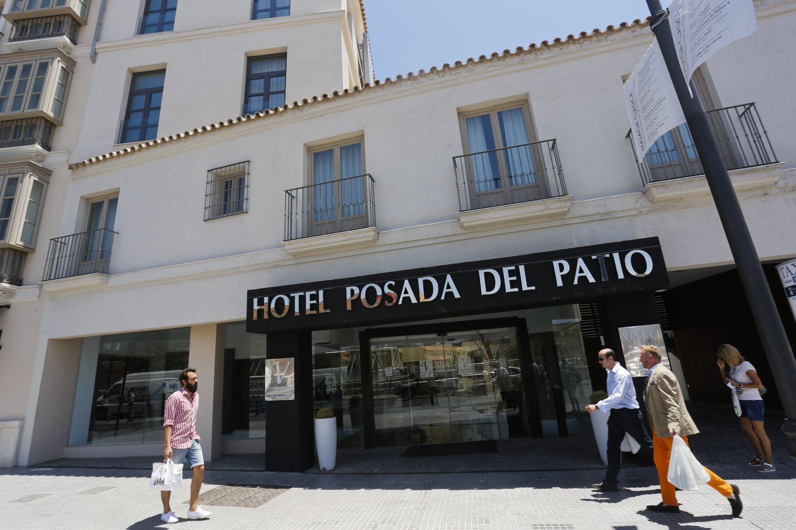 Varias personas pasan junto a un hotel en Málaga.