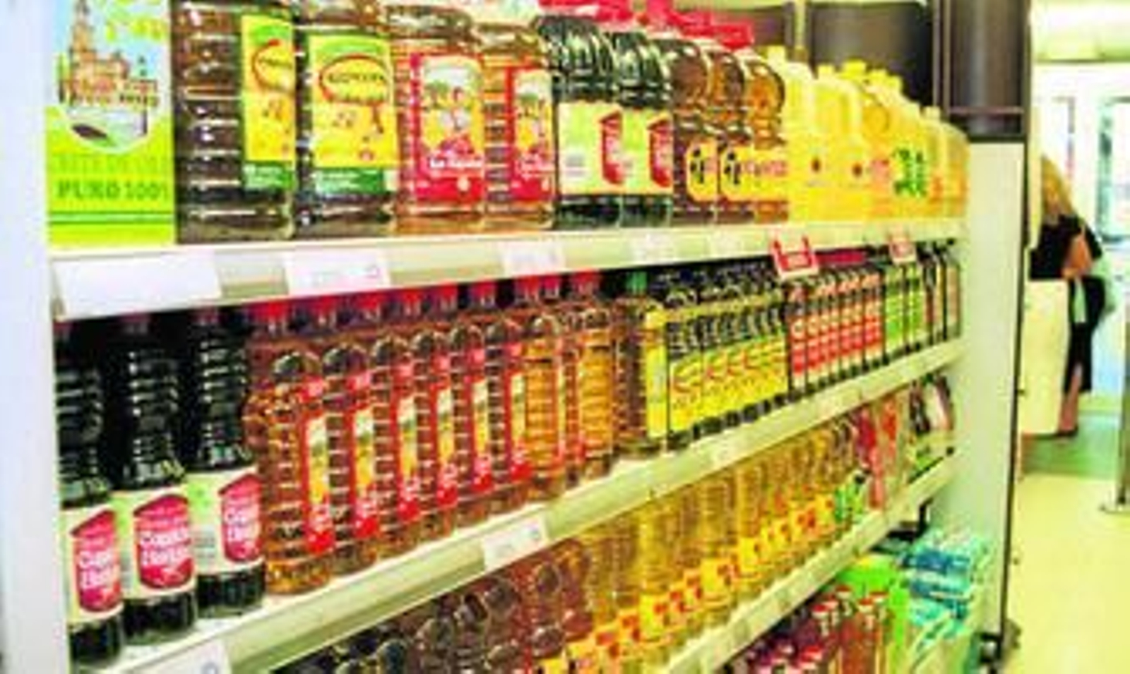 Botellas de distintas marcas de aceite de oliva en un supermercado.
