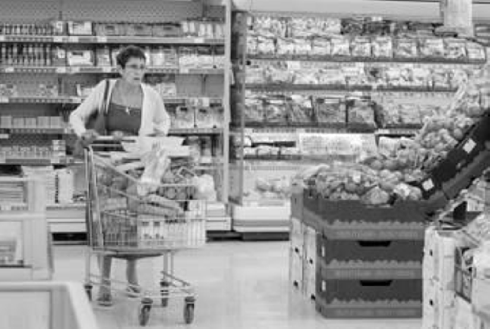 La clienta de un supermercado, con el carro de la compra lleno de alimentos.
