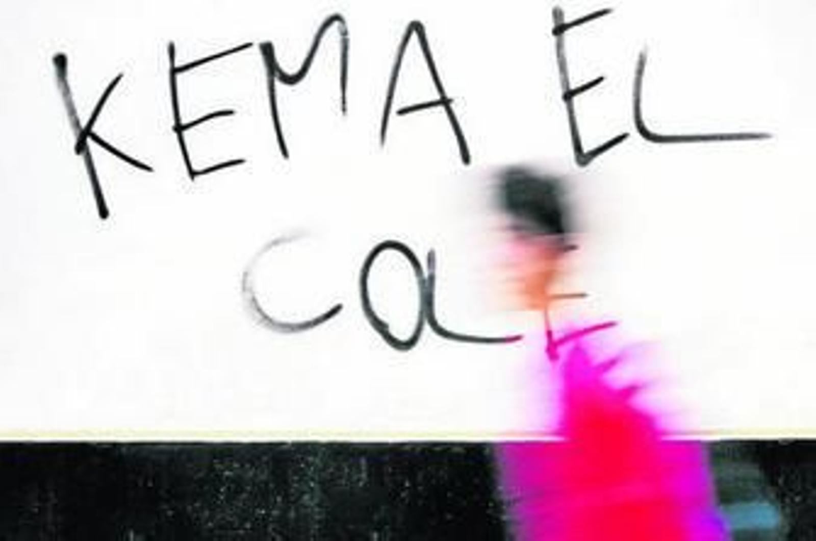 Un niño pasa ante una pintada en un colegio.