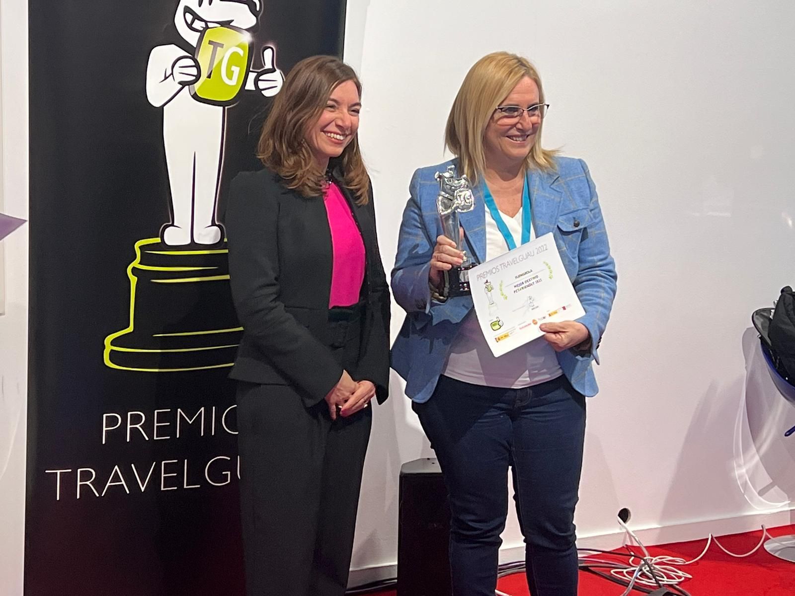 La alcaldesa, Ana Mula (D.), recogiendo el premio al mejor destino turístico para viajar con mascotas.