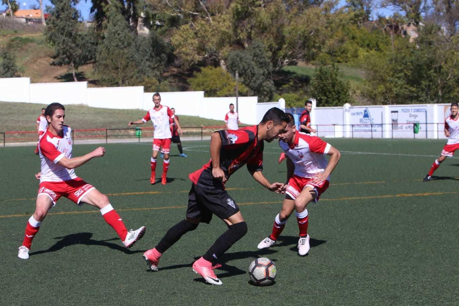 Sergio ‘Piojo’ se lleva el balón ante dos rivales en el partido frente al Ubrique.