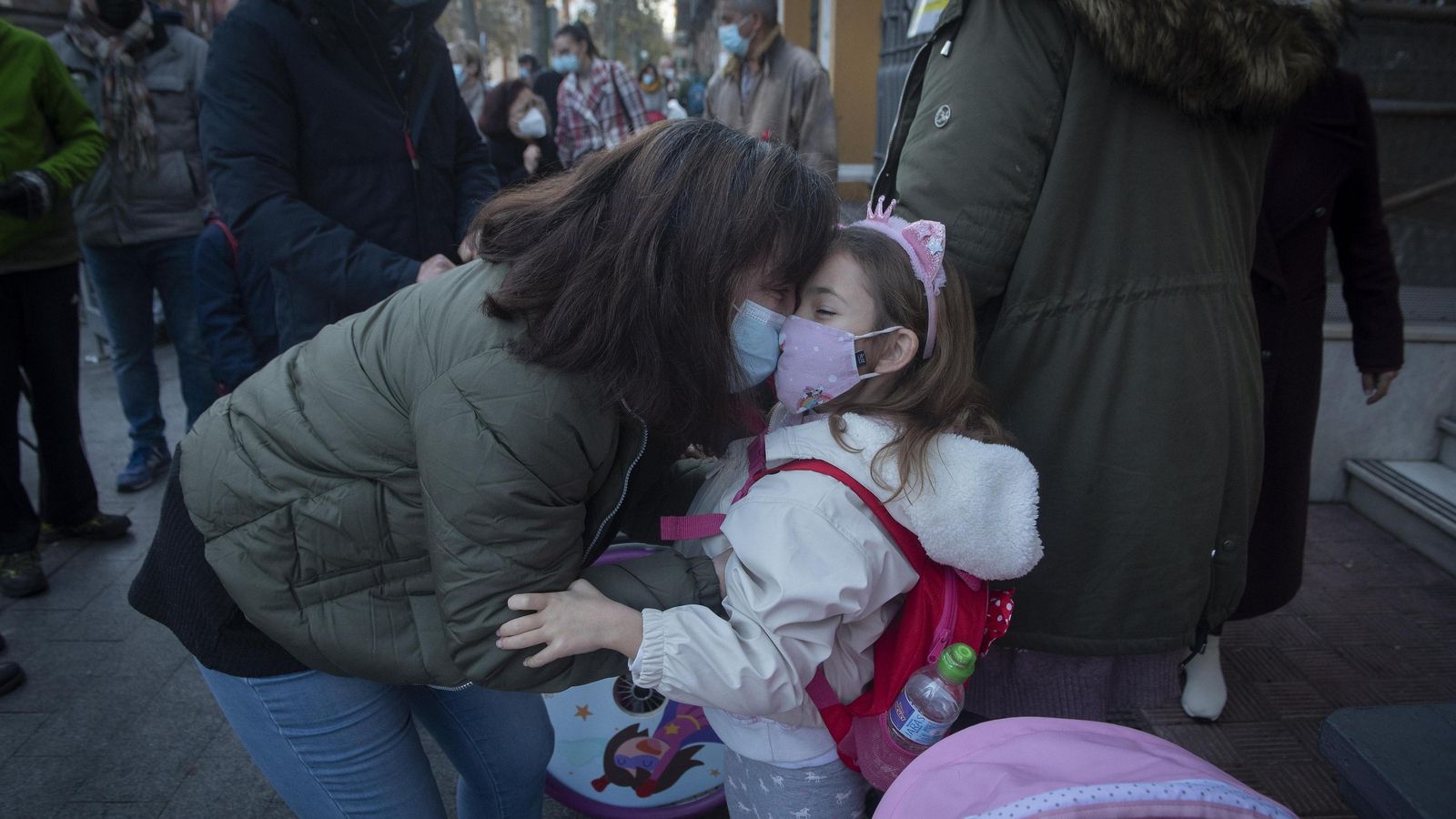 Una madre se despide de su hija antes de dejarla en el colegio.