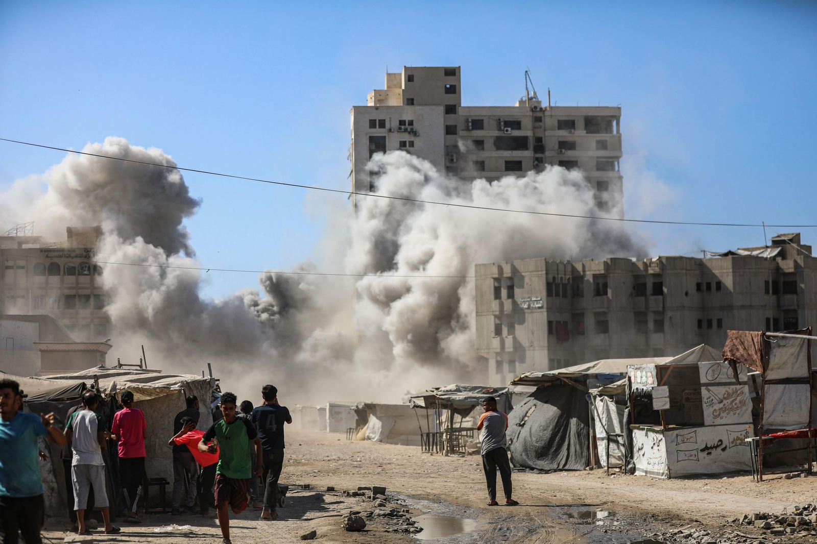 Varios palestinos observan un edificio derruido en Ciudad de Gaza.
