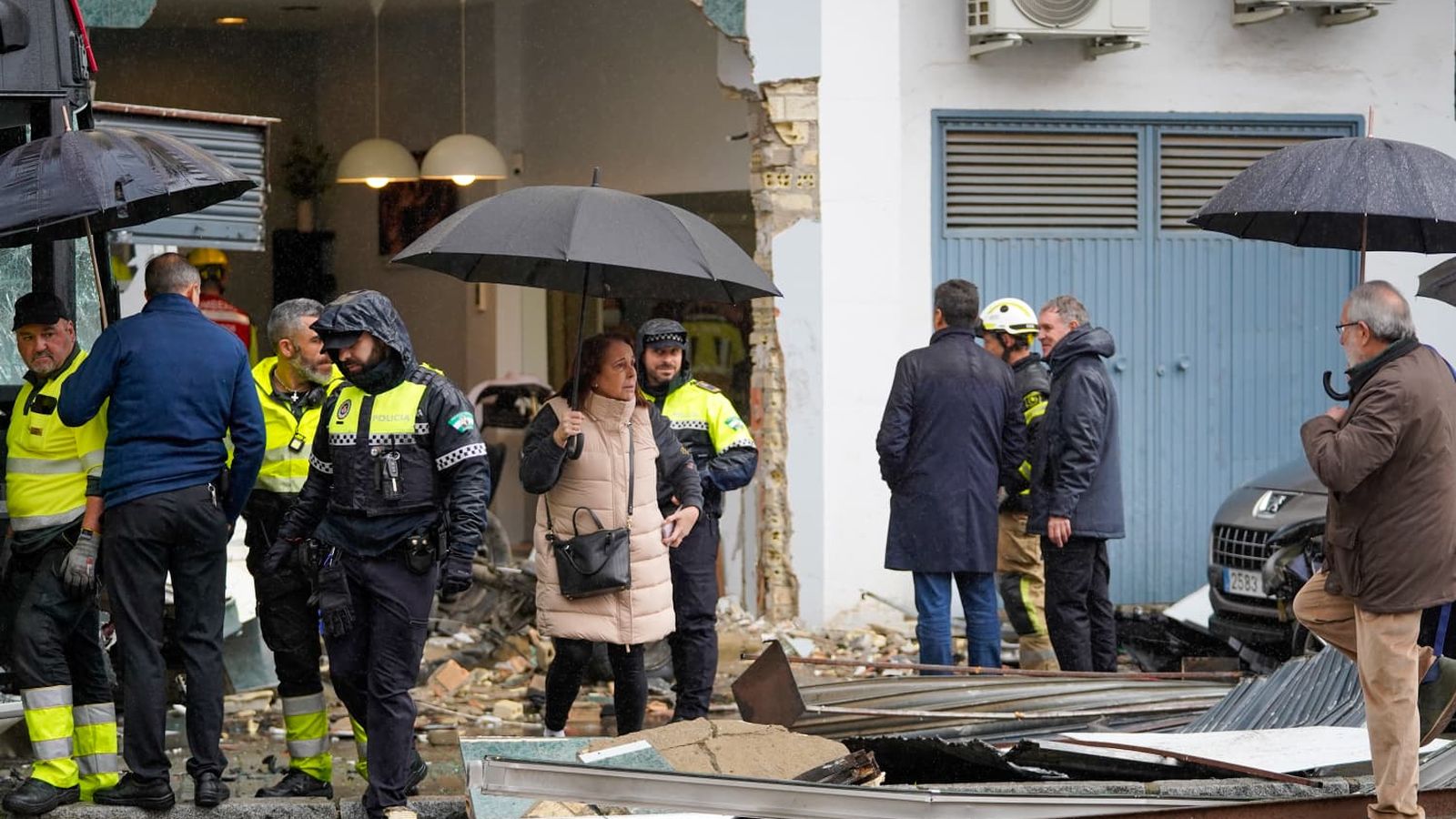 Salida de una de las clientas de la peluquería, acompañada un policía local.