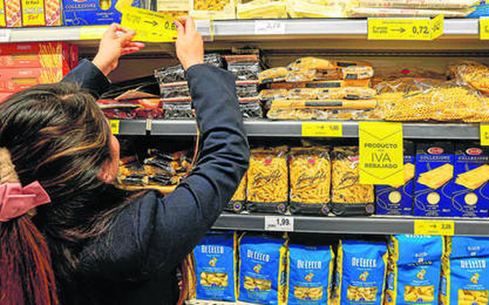 Una joven consulta los precios de la pasta en un establecimiento.