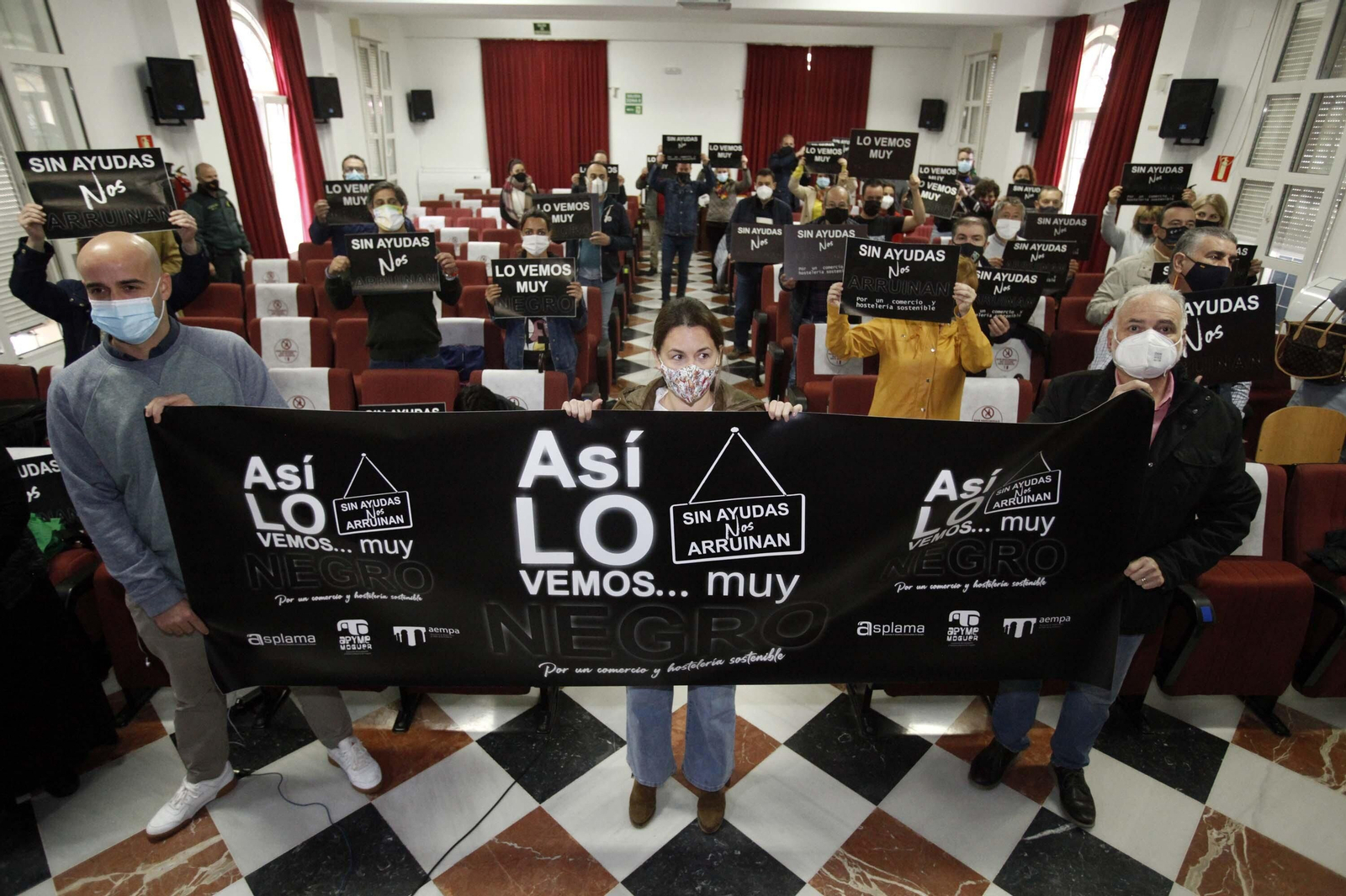 Empresarios y comerciantes exhiben carteles durante la concentración