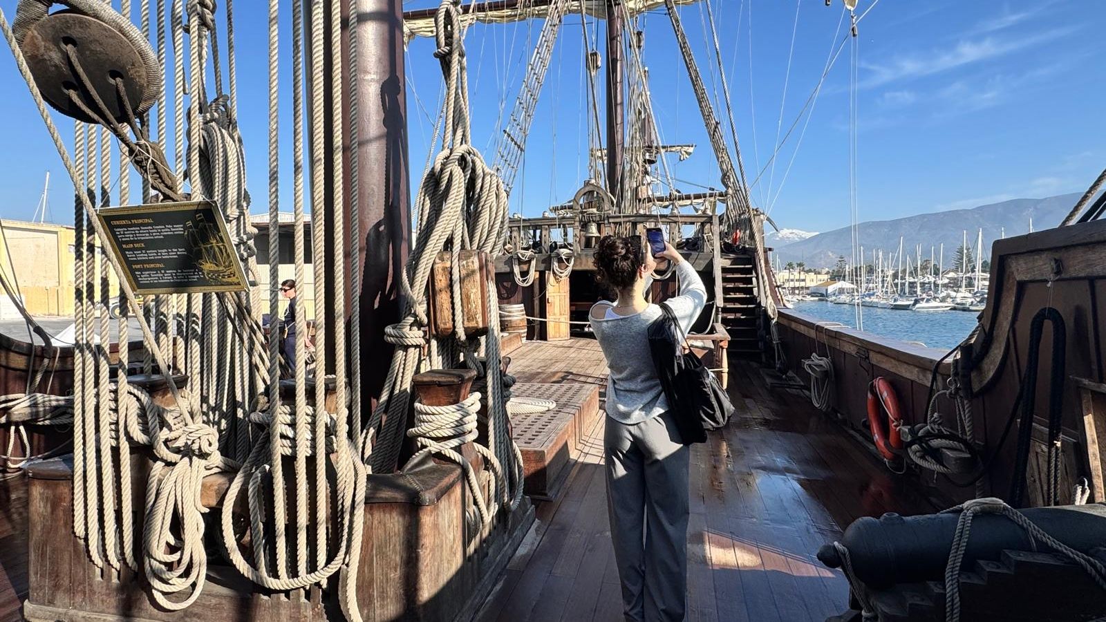 Una mujer fotografía una de las cubiertas del Galeón de Andalucía