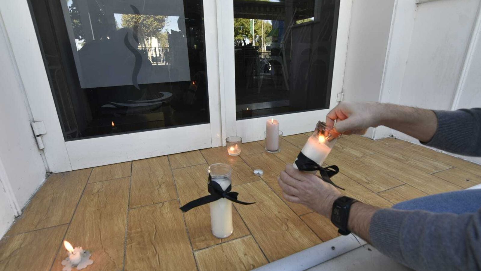 Las velas en recuerdo de María Isabel M. M., este lunes a las puertas de su negocio en San Roque.