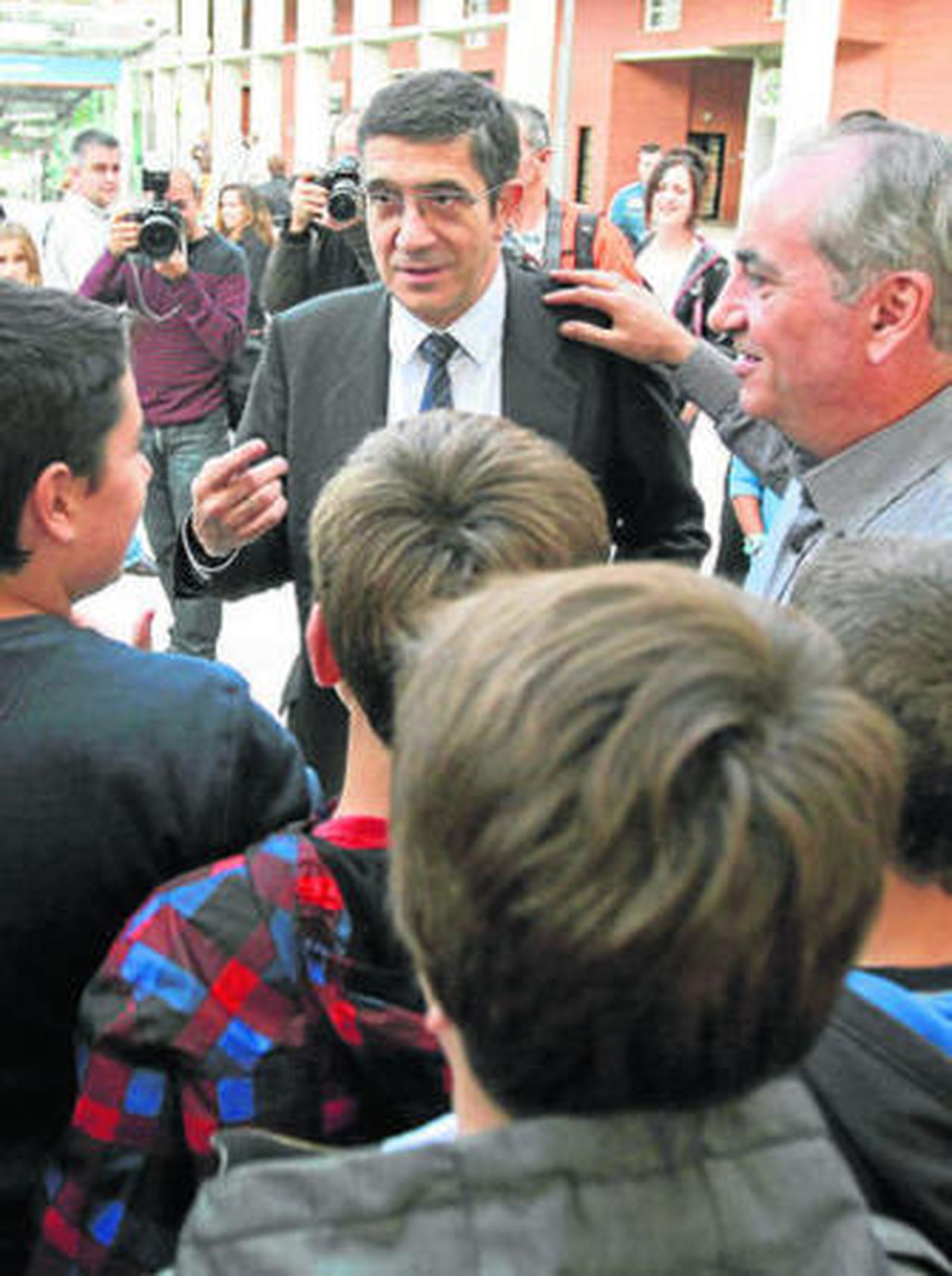 Patxi López atiende a unos menores durante un acto socialista en plena calle.