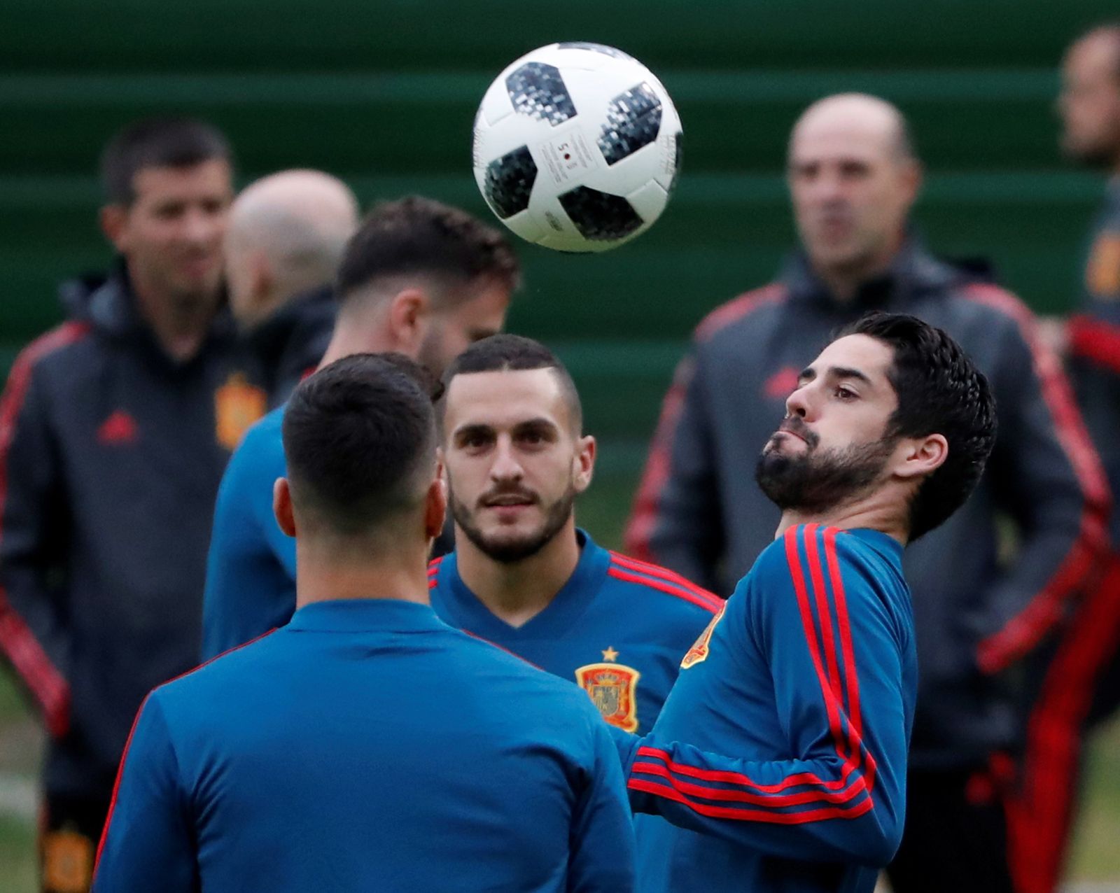 Isco, Koke y Marcos Asensio, de espaldas, juegan con la pelota.