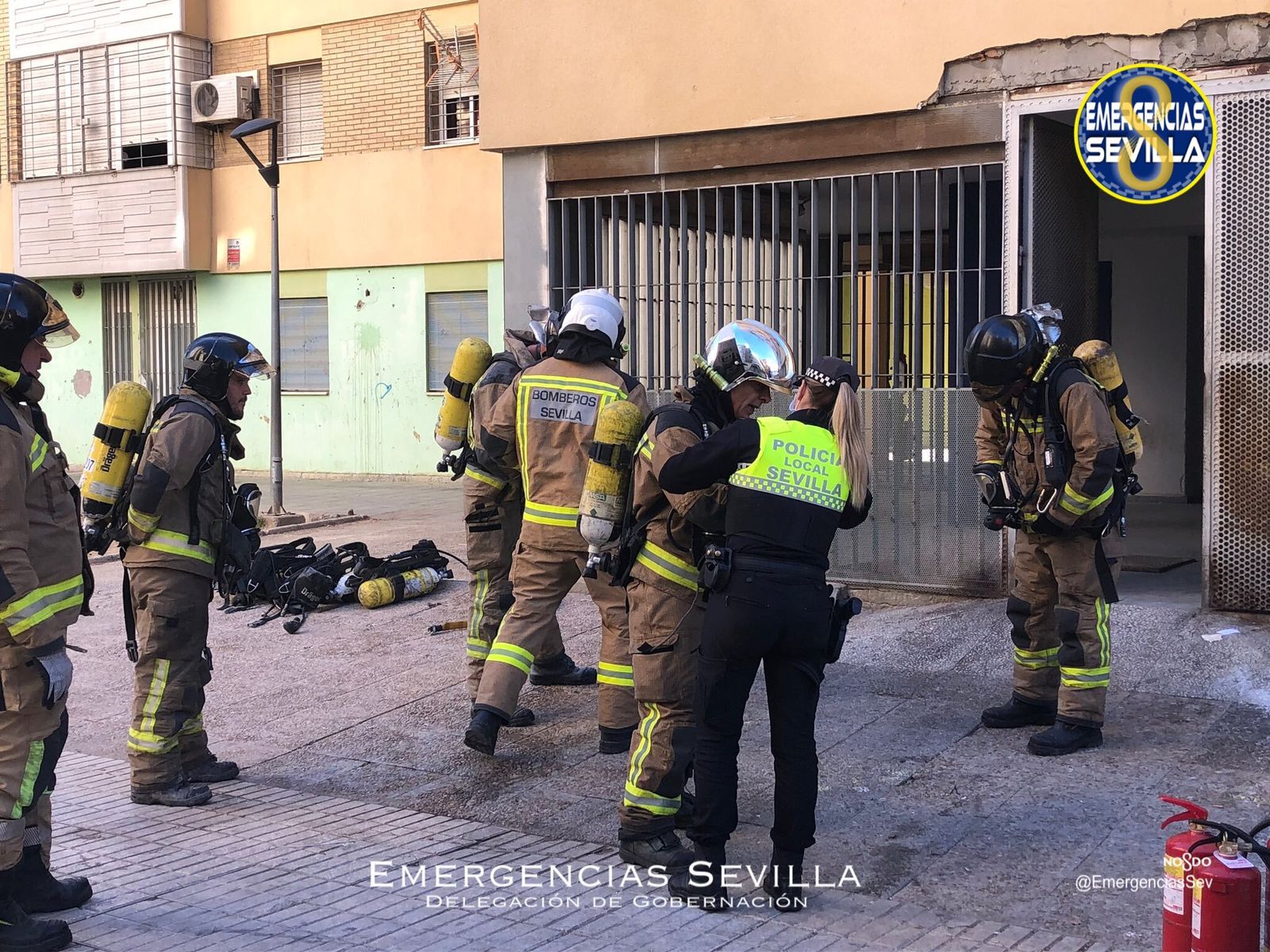 Los bomberos y la Policía Local trabajan en el bloque del incendio.