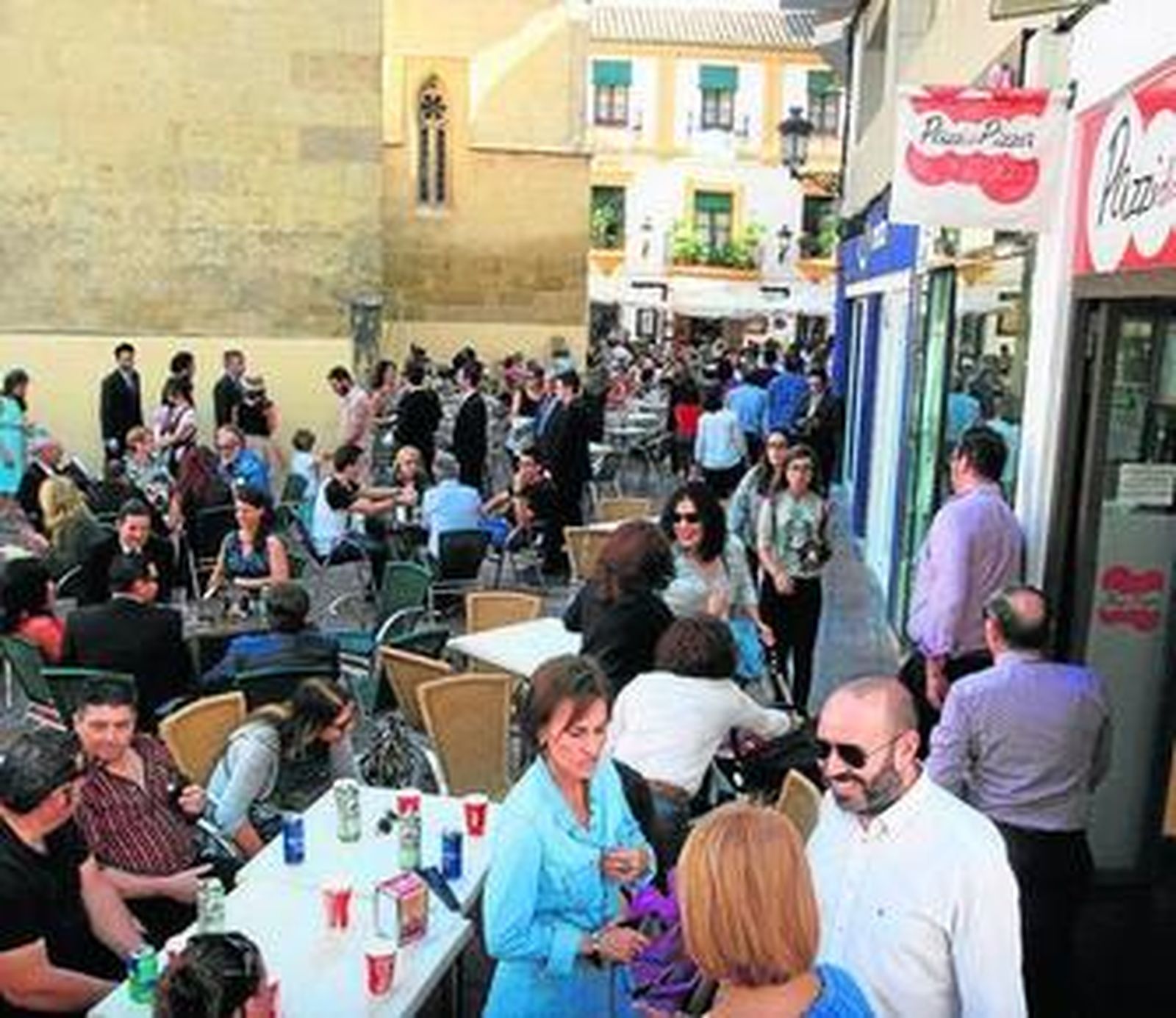 Foto de archivo de varias terrazas de negocios de hostelería repletas.