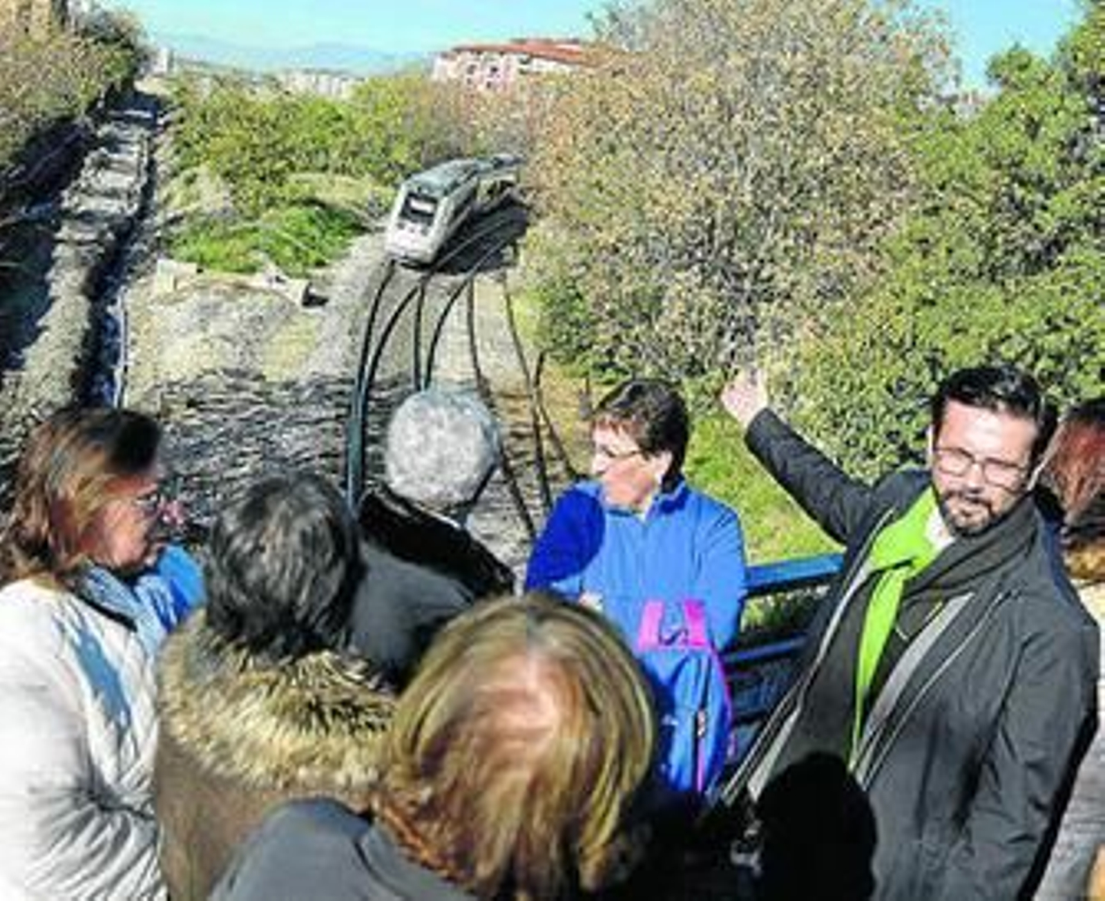 Un tren recorre las vías mientras los vecinos y Paco Cuenca denuncian la división.