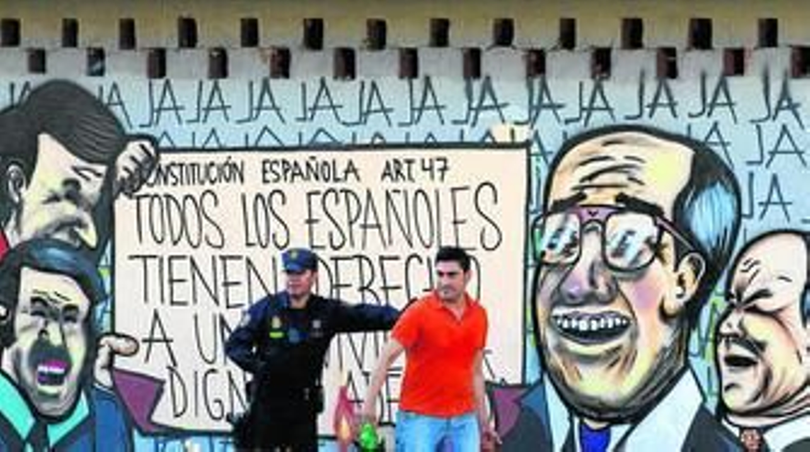 Un agente de la Policía Nacional y uno de los ocupantes del edificio, durante el desalojo del pasado domingo.