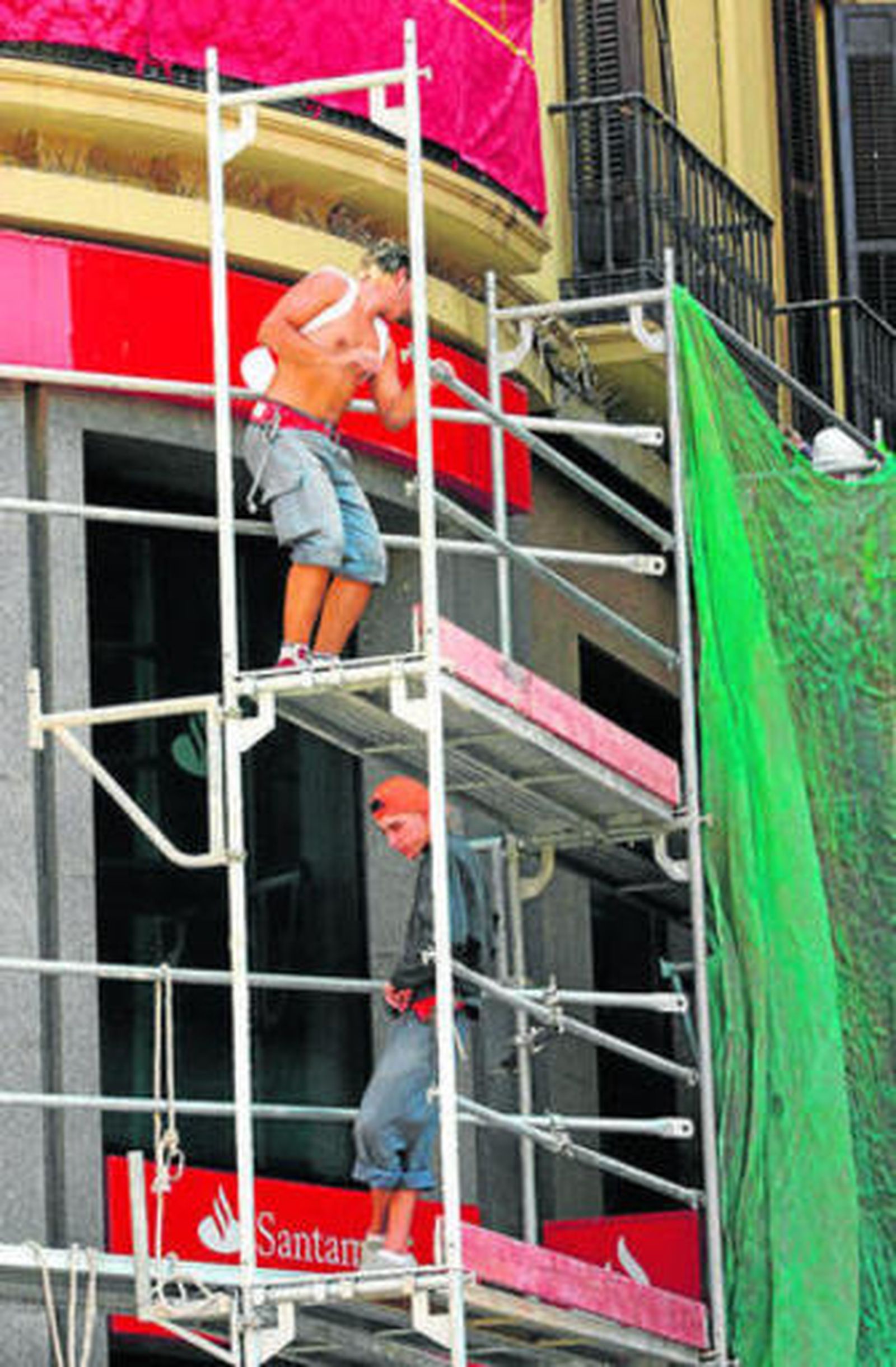 Dos trabajadores en un andamio en Málaga.
