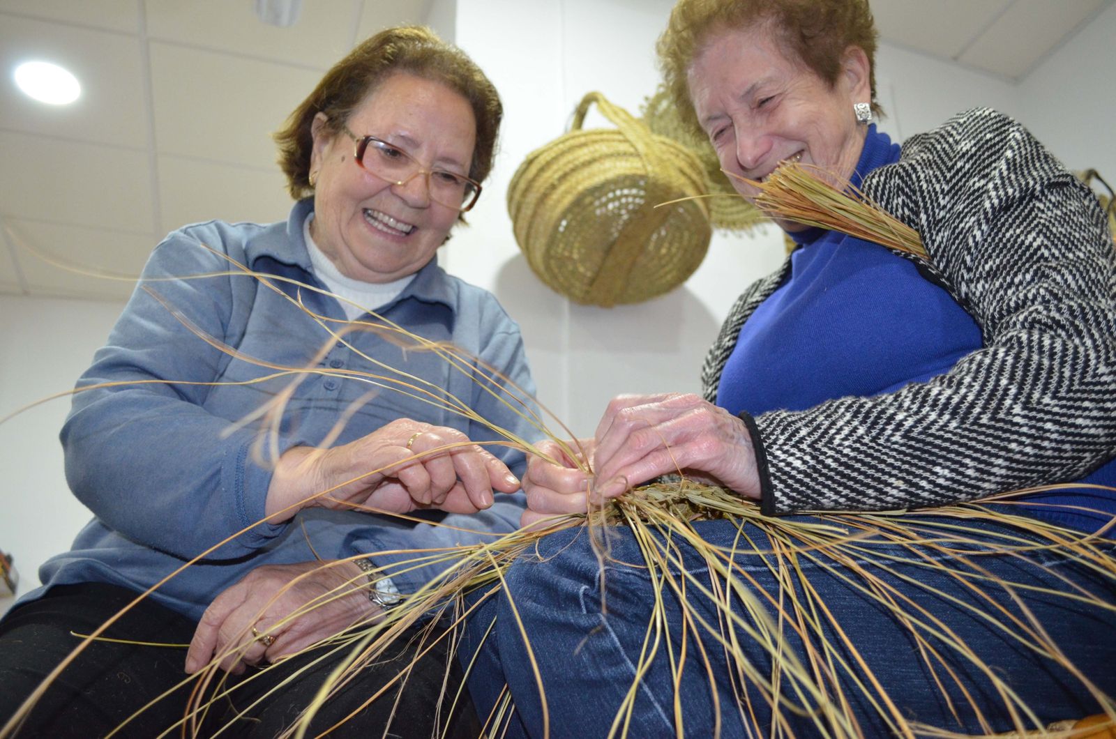 Dos mujeres trabajan con esparto.