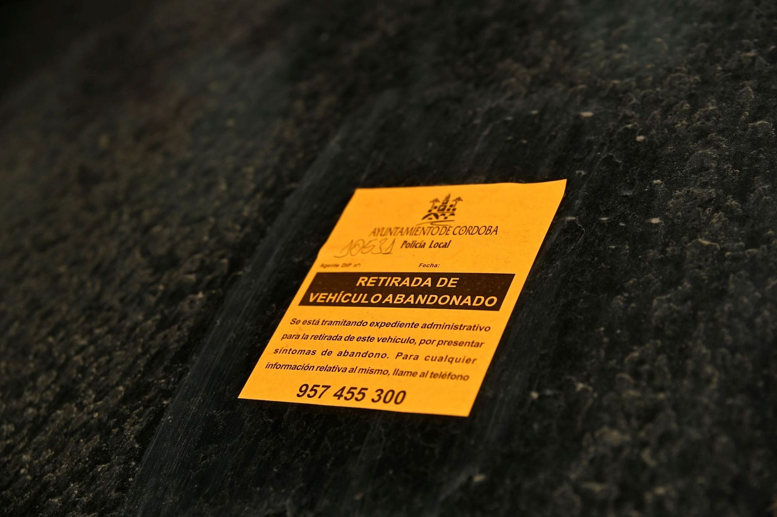 Pegatina naranja que señaliza un vehículo abandonado en Córdoba.
