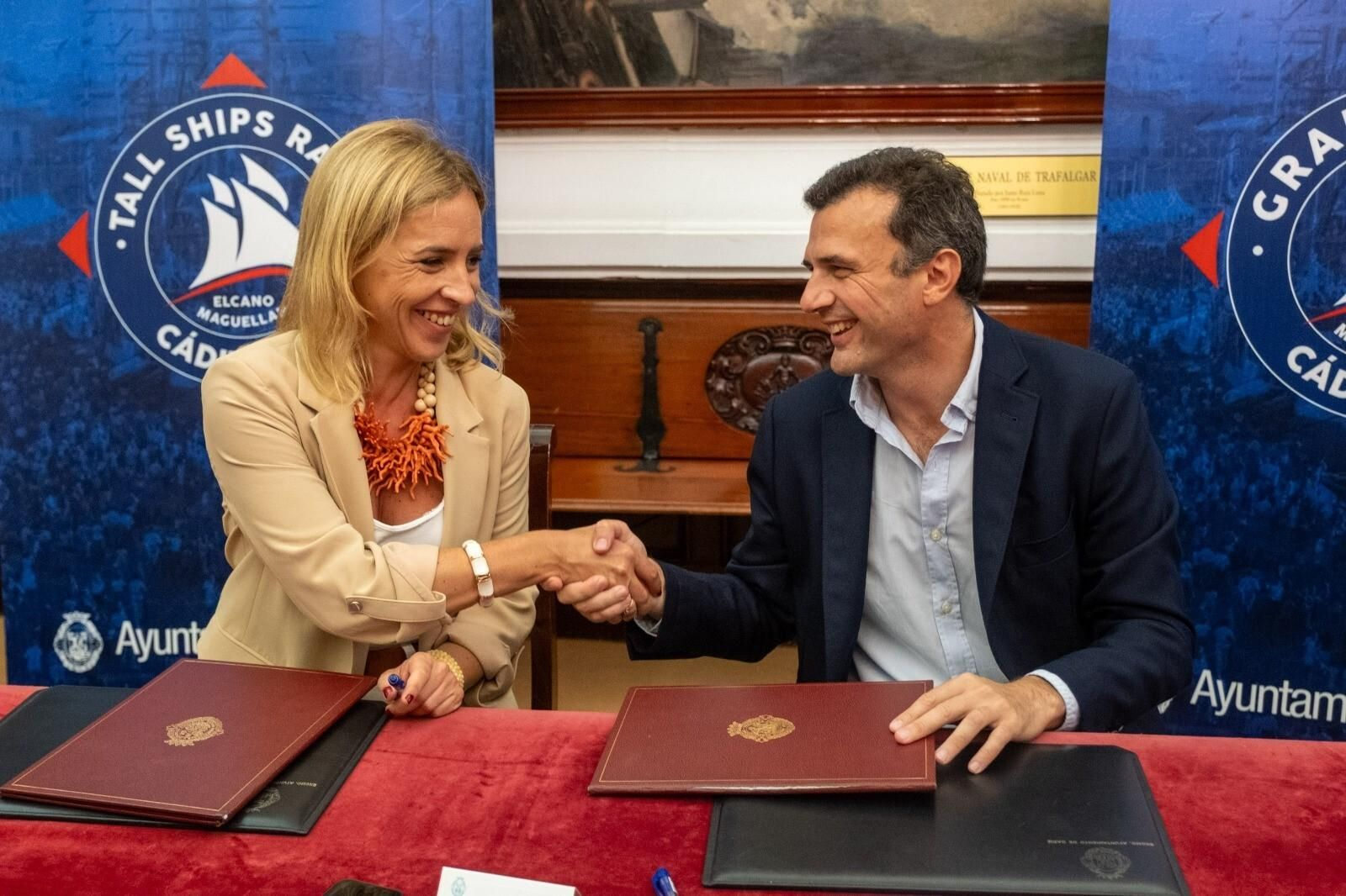 La presidenta de la Diputación de Cádiz y el alcalde estrechan su mano tras firmar el convenio para la Regata.