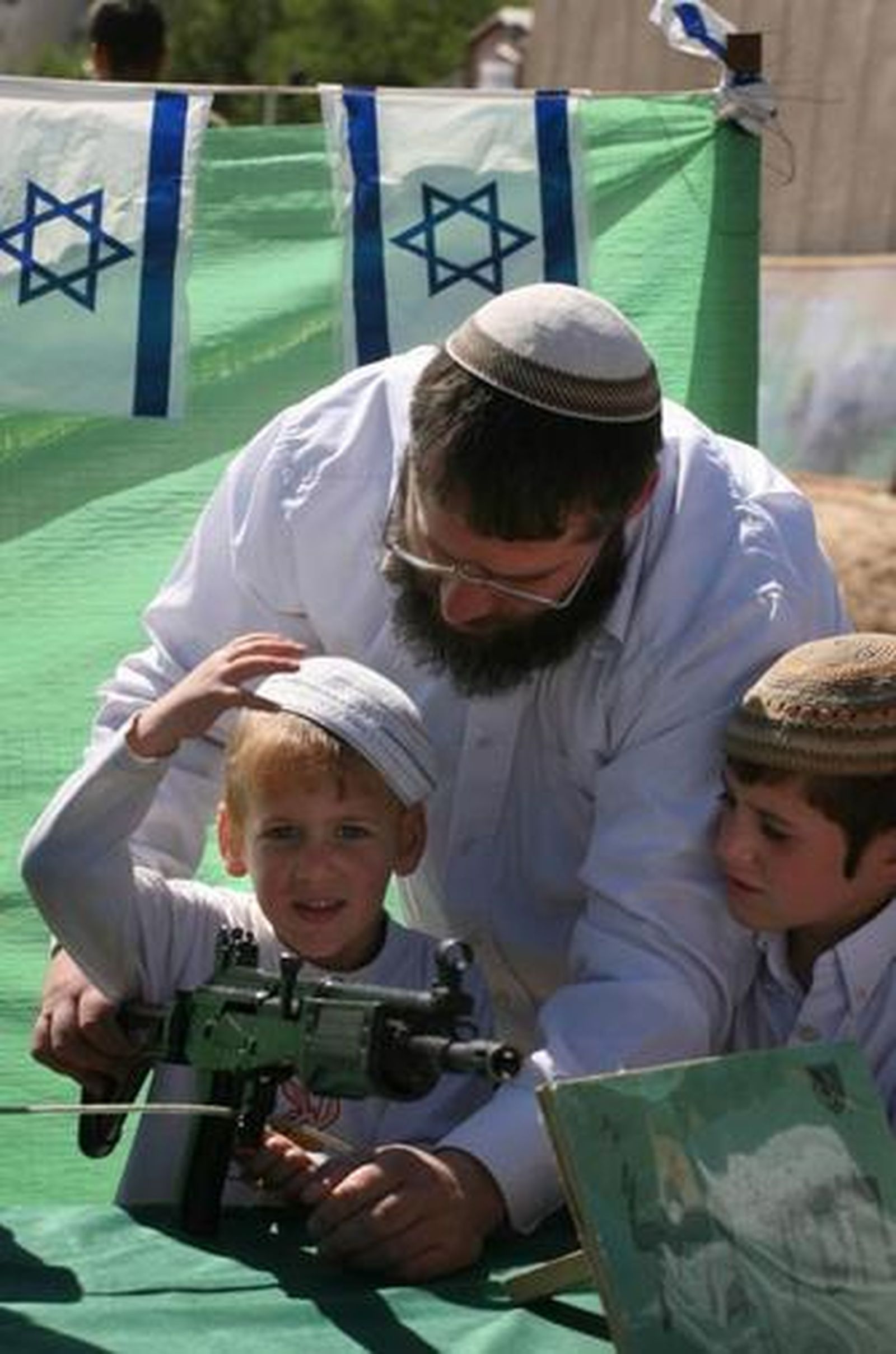 Un niño juega con un arma de las Fuerzas Armadas israelíes.