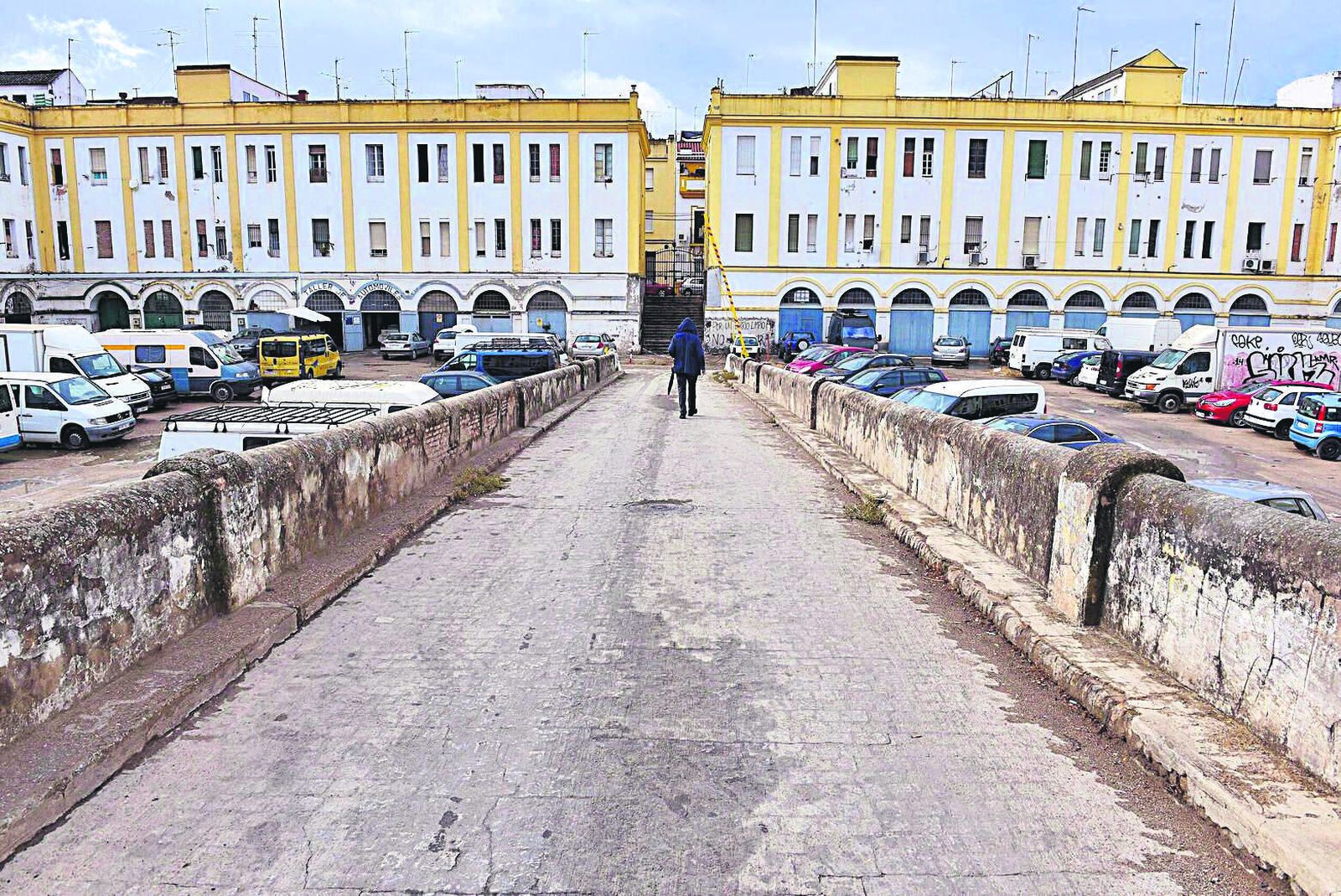 Un hombre camina por el gran patio de las Casas de Pinillos, entre las calles Júpiter y Luis Cadarso.