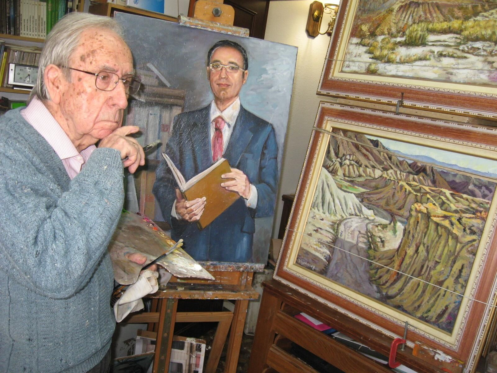 Rafael, pincel y paleta en mano, observando sus cuadros.