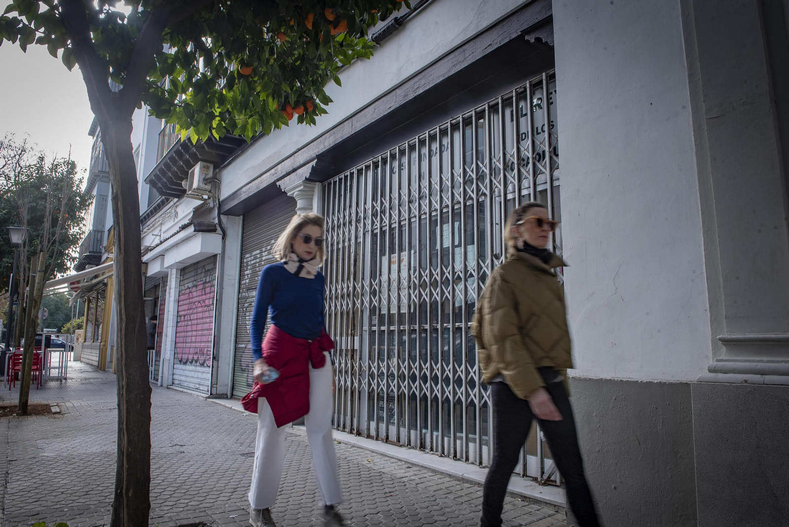 Dos mujeres pasan junto a la puerta de uno de los dos locales, era el bar Casa Florencio, que el Ayuntamiento tiene a la venta en la calle Abogada Aurora León.