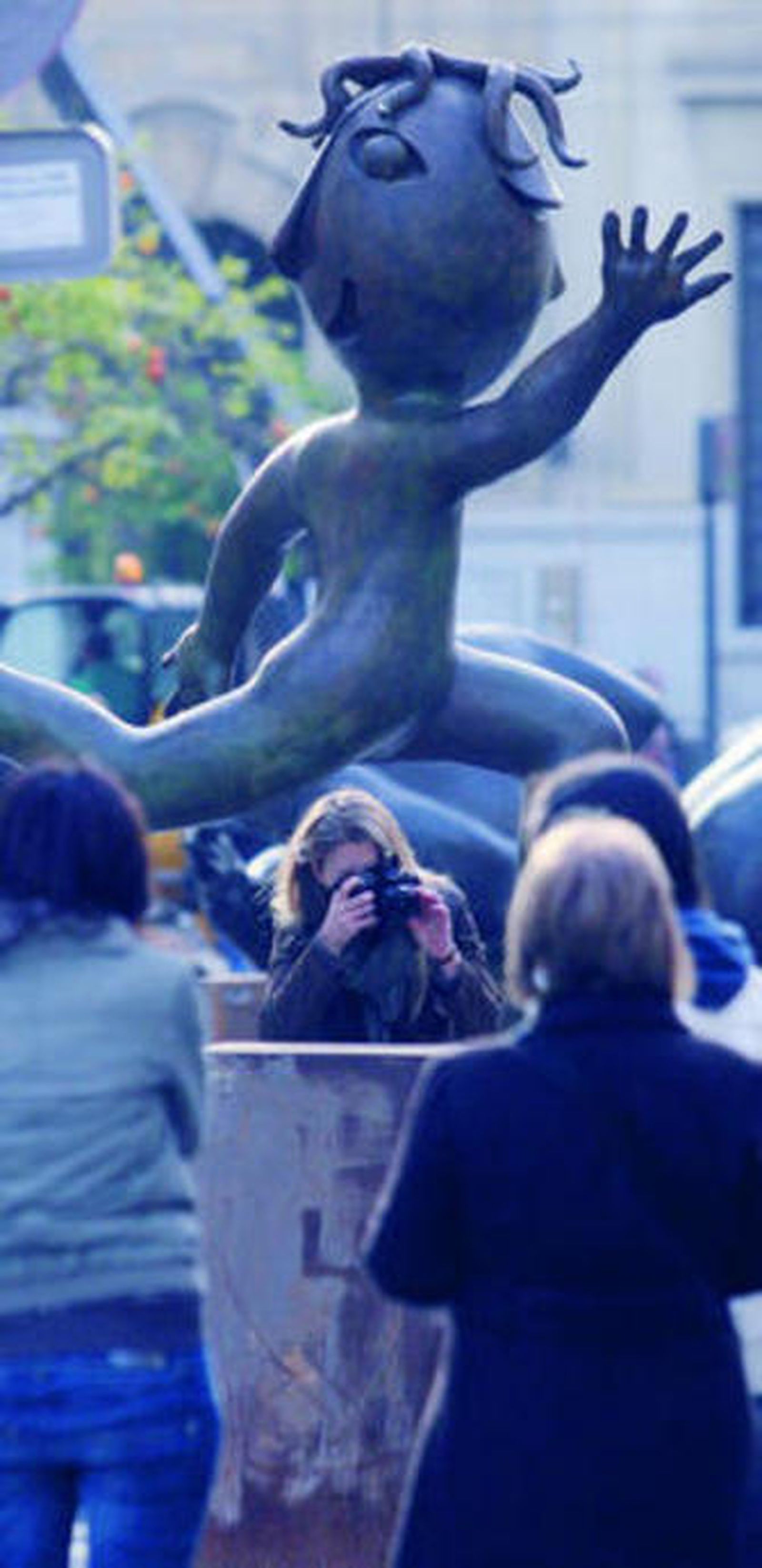 Transeúntes observan una de las piezas de la muestra.