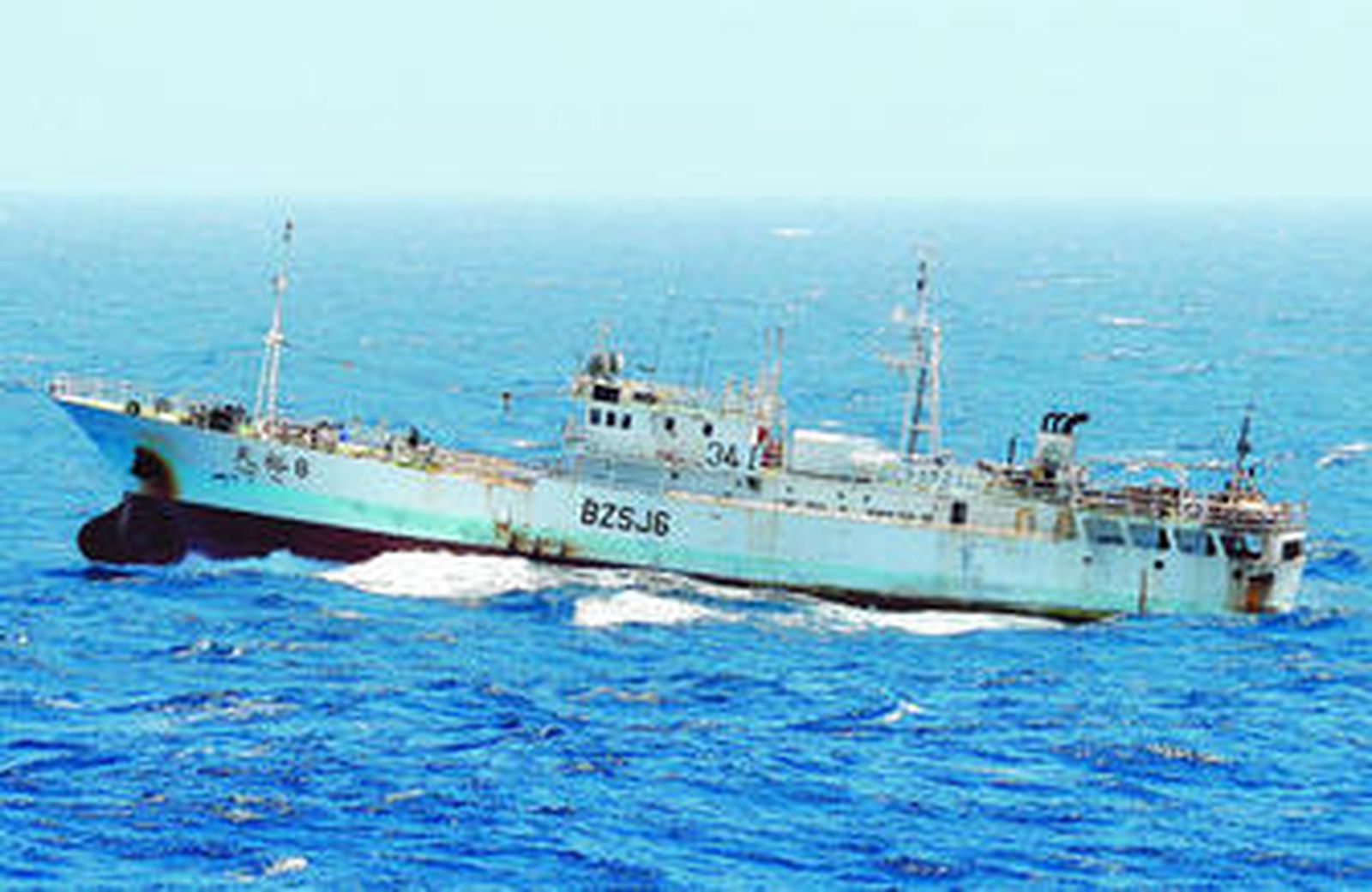 Un grupo de piratas asoman en la cubierta del pesquero apresado en el océano Índico.