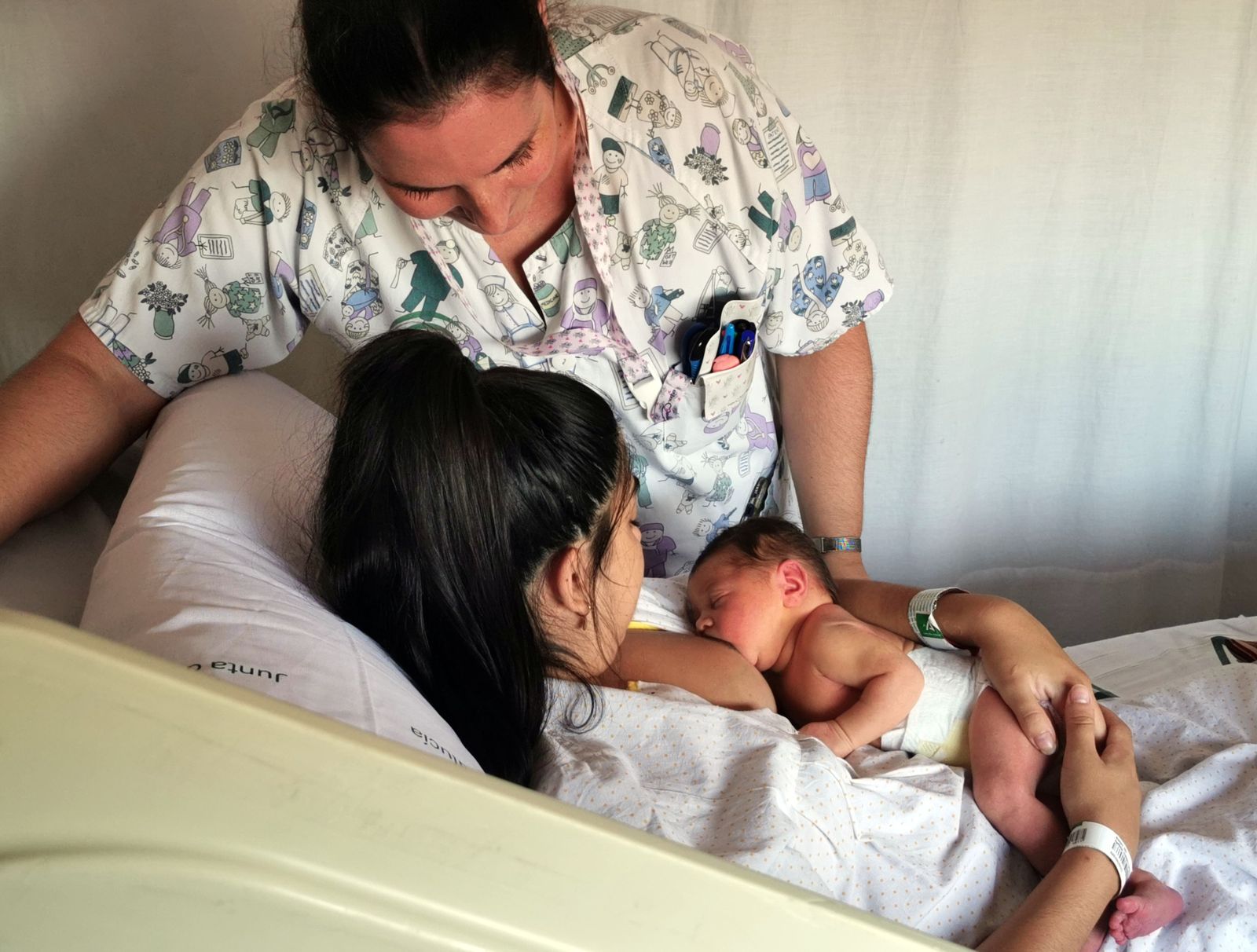 Auxiliar de enfermería de la planta de Maternidad apoyando a la madre en el mantenimiento de la lactancia materna.
