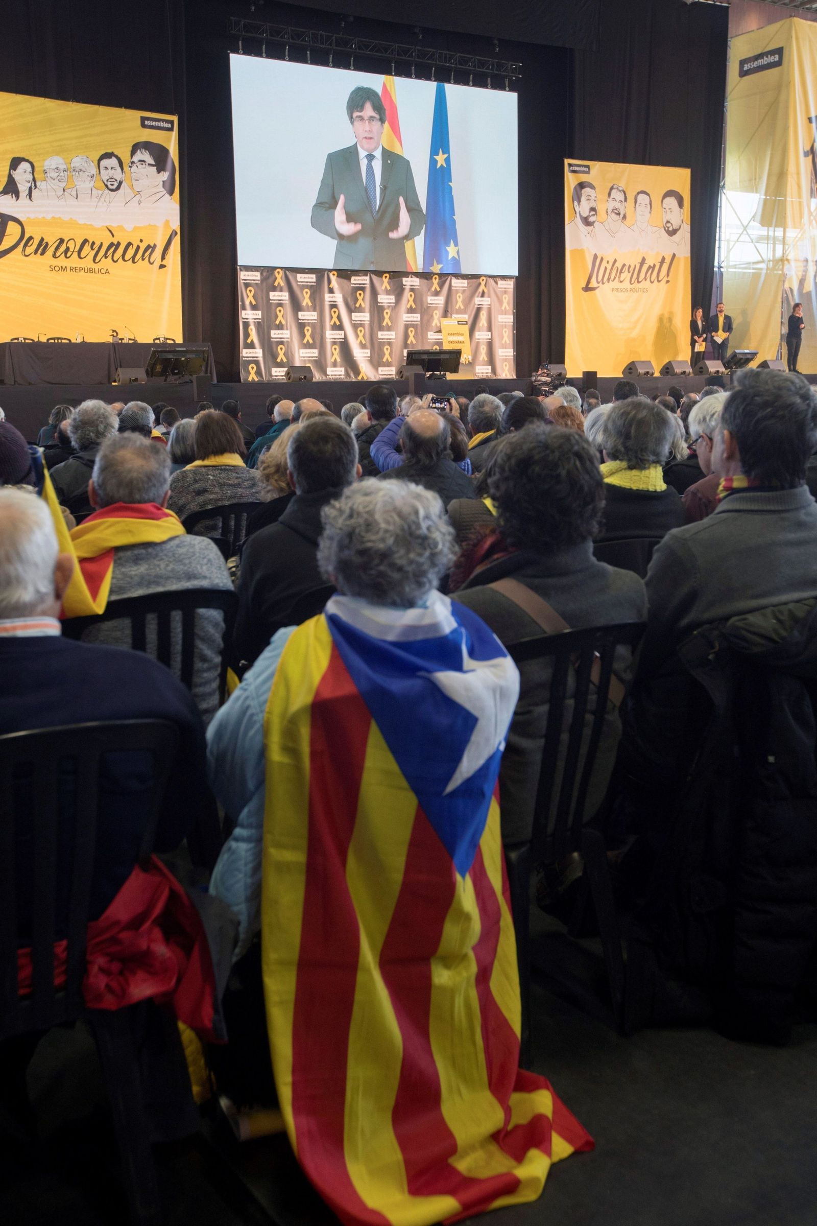 Los asistentes a la asamblea de ANC ayer ven una proyección de Puigdemont.